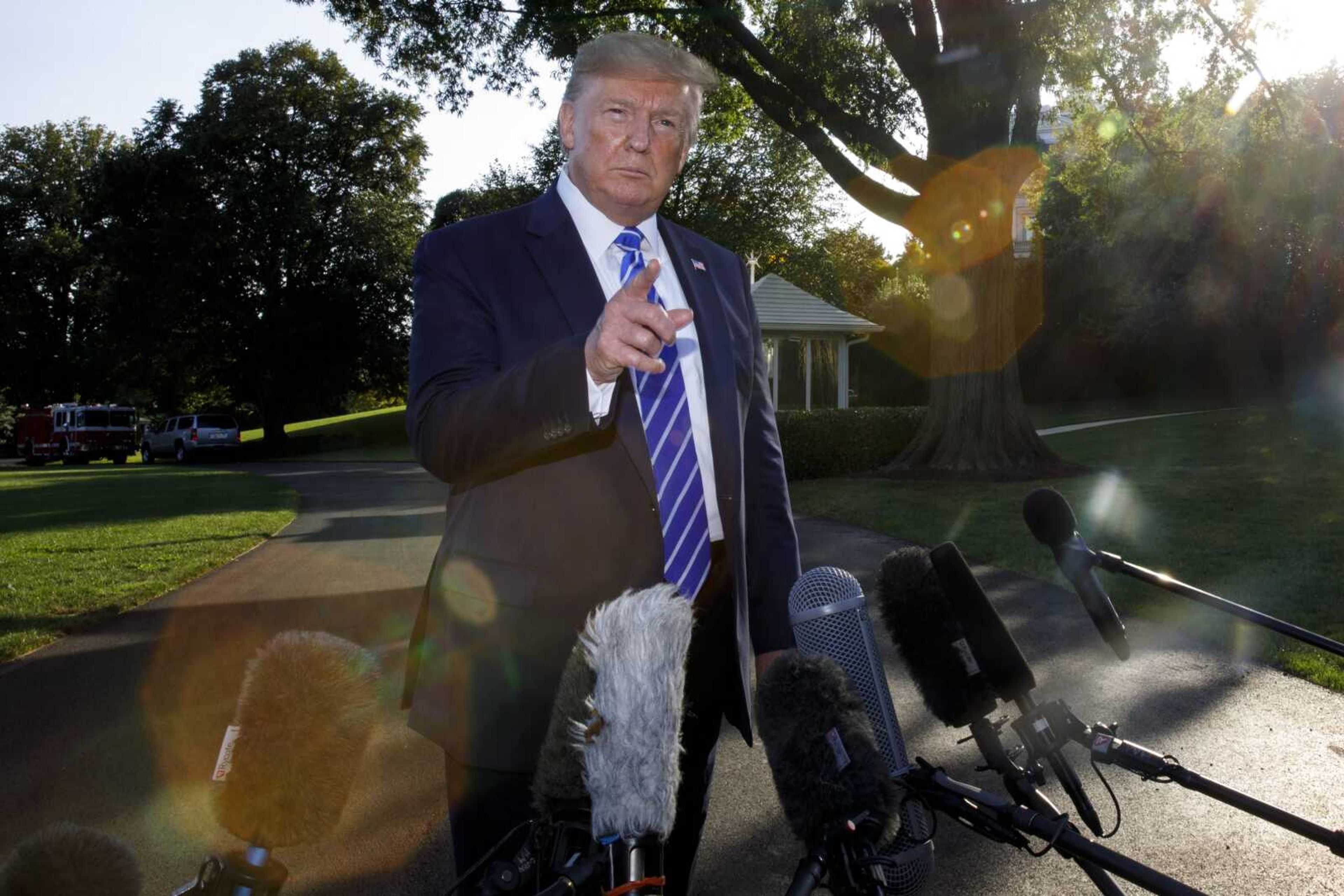 President Donald Trump takes questions from the media Friday before boarding Marine One at the White House in Washington.