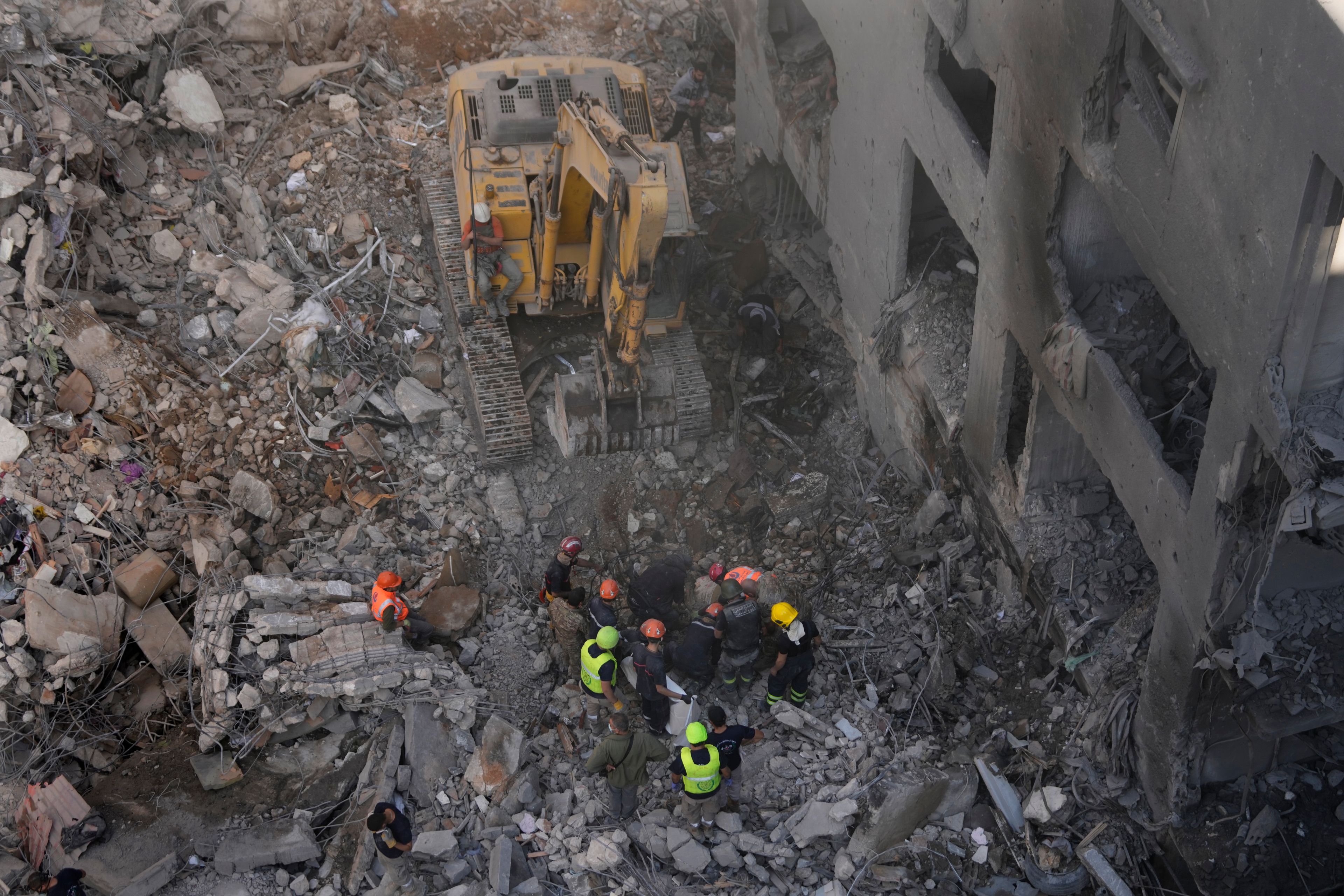 Rescue workers search for victims at the site of an Israeli airstrike that hit central Beirut, Lebanon, Saturday, Nov. 23, 2024. (AP Photo/Hussein Malla)