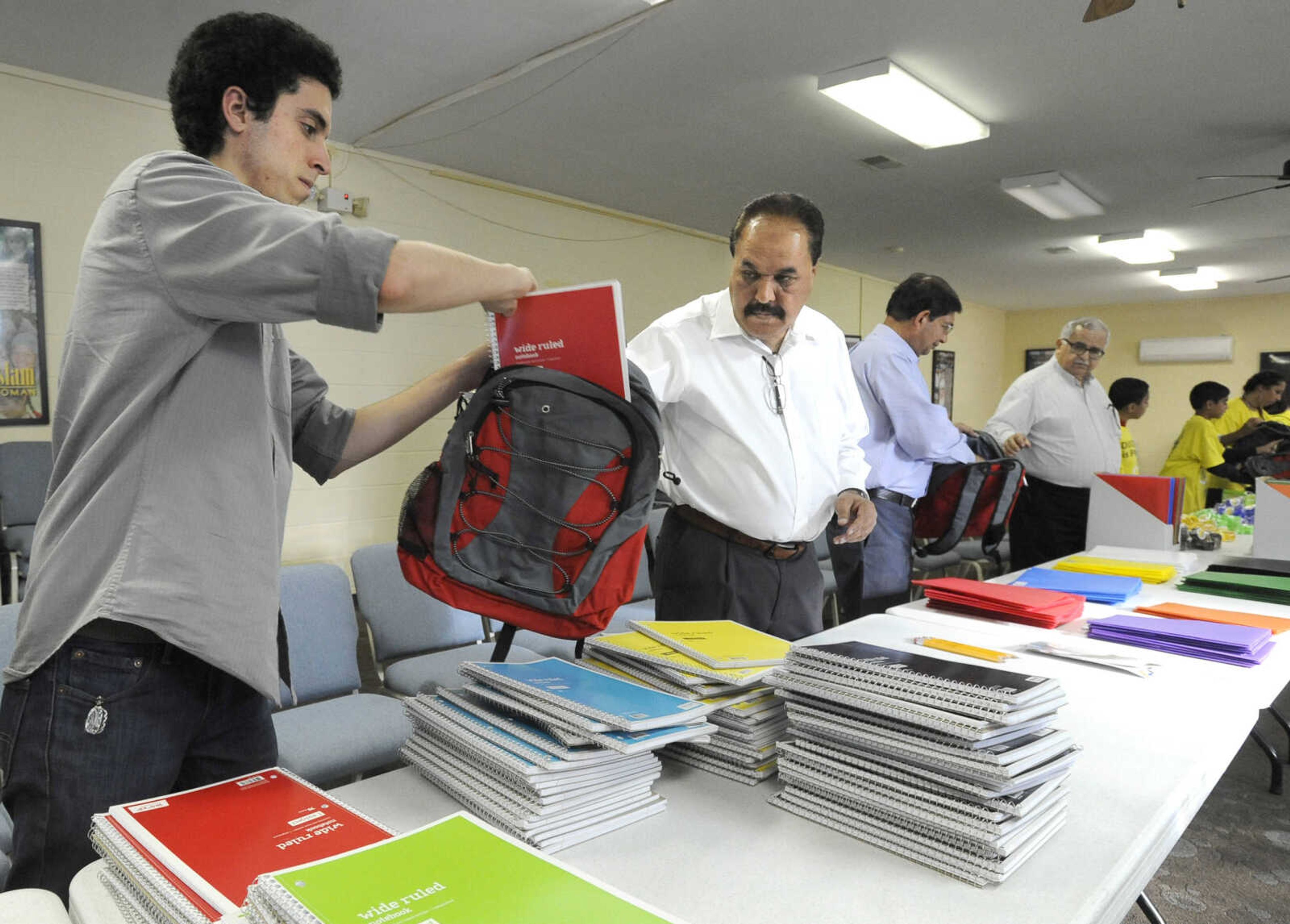 FRED LYNCH ~ flynch@semissourian.com
Ahmed Imam, left, passes a backpack to Shafiq Malik as they fill them with basic school supplies Tuesday, Aug. 1, 2017 at the Islamic Center of Cape Girardeau.