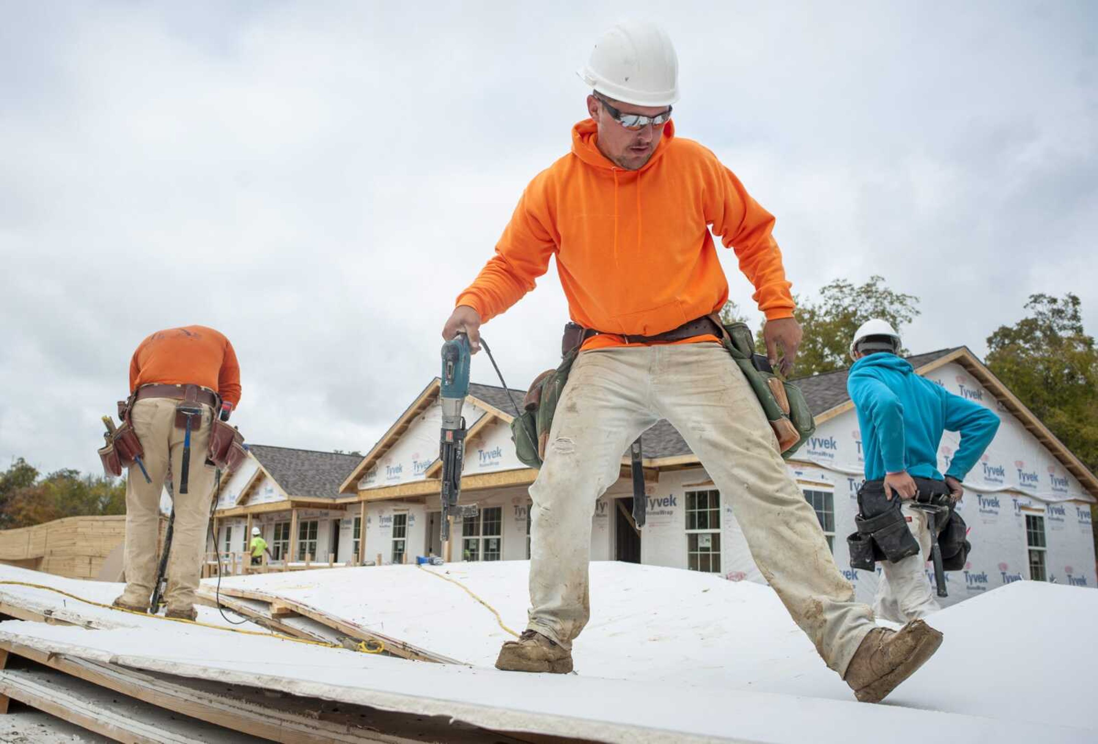 Carpenter Beau Missey of Potosi, Missouri, center right, nails sheetrock to a truss Monday at the future site of Liberty Apartments in Cape Girardeau.