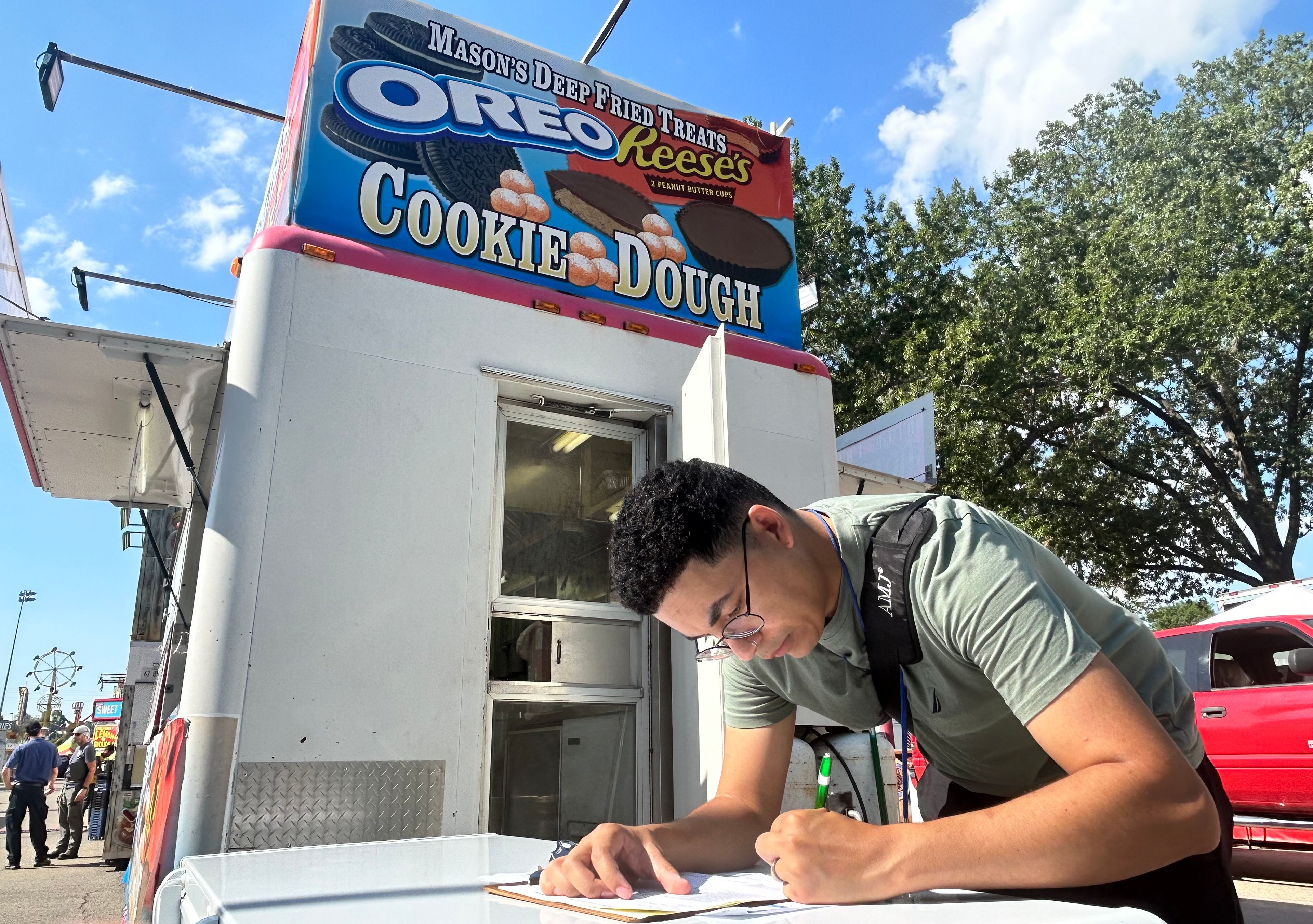 Anthony Mitchell, an inspector with the Cape Girardeau County Public Health Center, fills out paperwork for an inspection of a food trailer at the SEMO District Fair on Friday morning, Sept. 6, at Arena Park in Cape Girardeau.