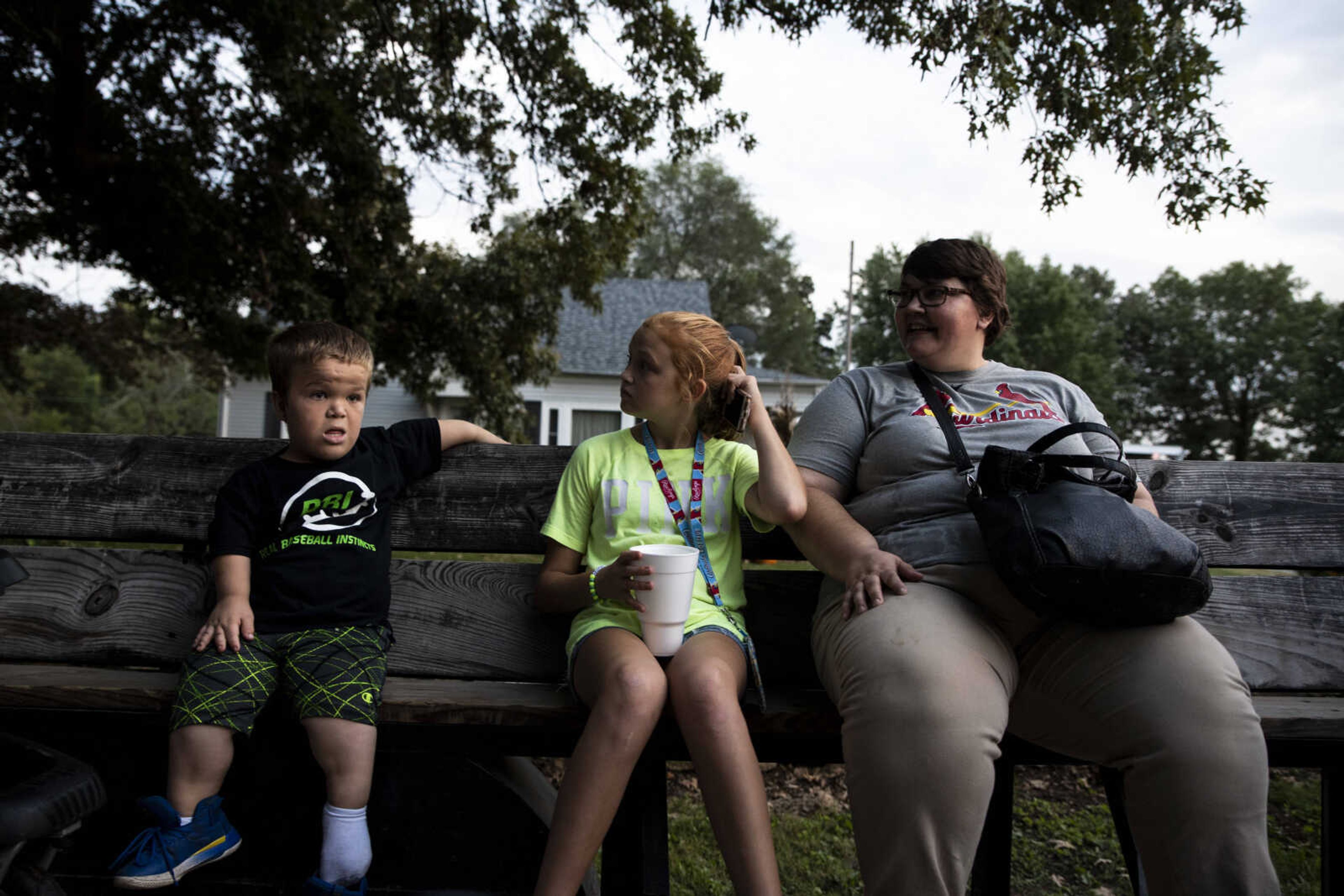 From left, Izaac Pursley sits on a wagon bench with Evee-Kay Pursley and Angie Eifert while visiting the East Perry Community Fair Sept. 21, 2018, in Altenburg.