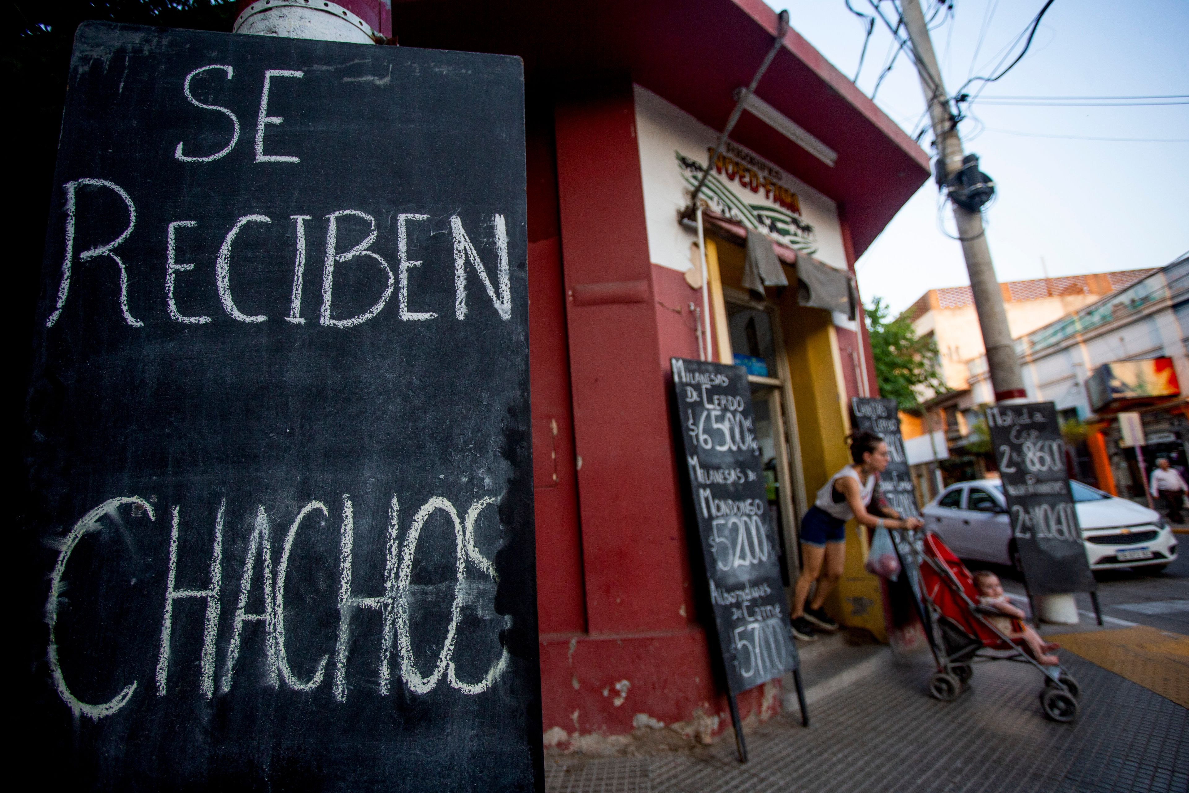 A sign reads in Spanish, "We take chachos" at a butcher shop in La Rioja, Argentina, Monday, Sept. 23, 2024. In response to slashed federal budgets to provinces, La Rioja is printing a new emergency tender called "chachos" to pay state workers and spur the economy. (AP Photo/Natalia Diaz)