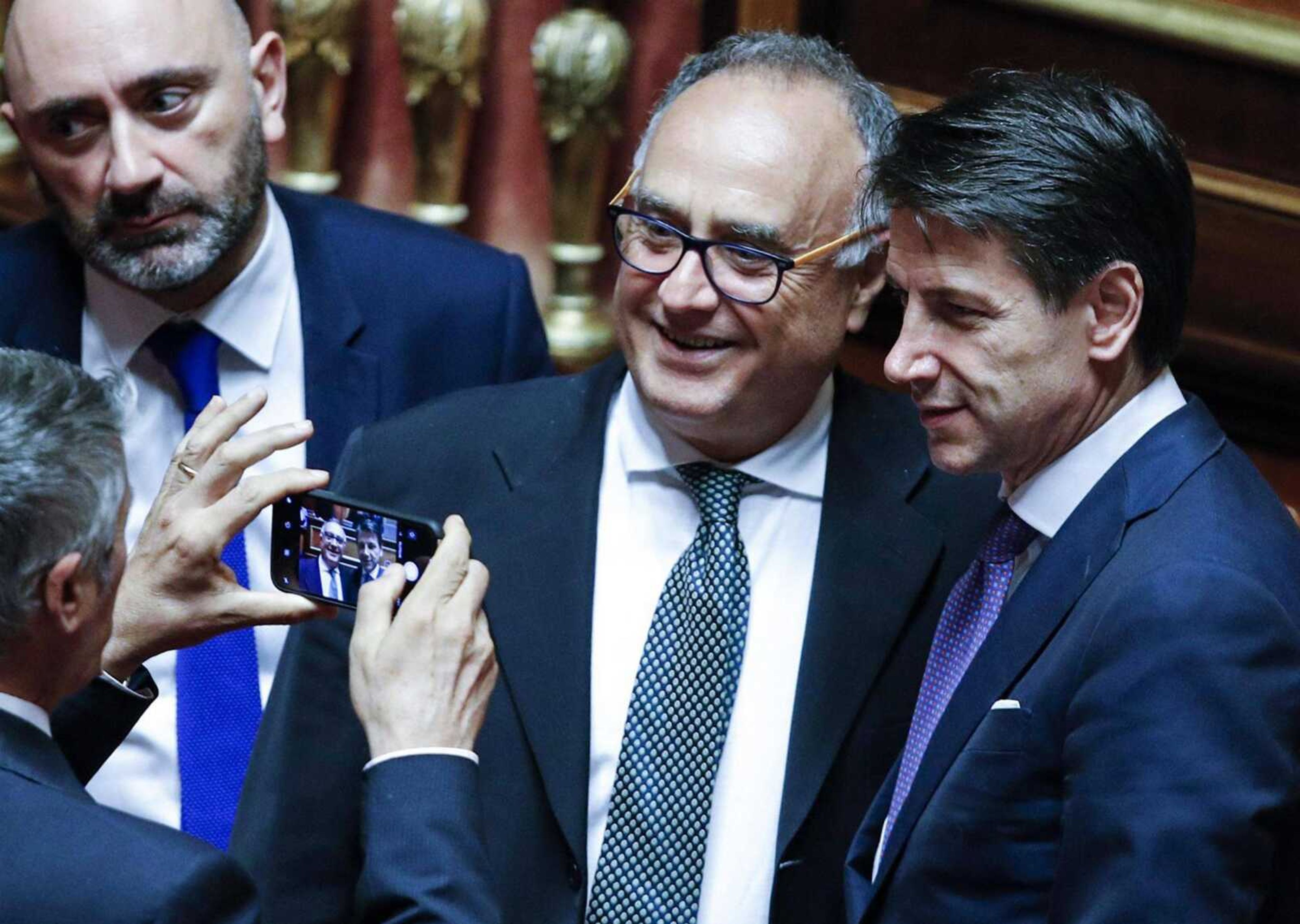 Senators take photos Tuesday with Italian Premier Giuseppe Conte, right, at the Senate in Rome. Italy's new populist government won the first of two votes of confidence needed to start governing after its leader denounced Europe's "failed" immigration policy and warned his Cabinet would renegotiate Italy's fiscal obligations so it can help struggling Italians.