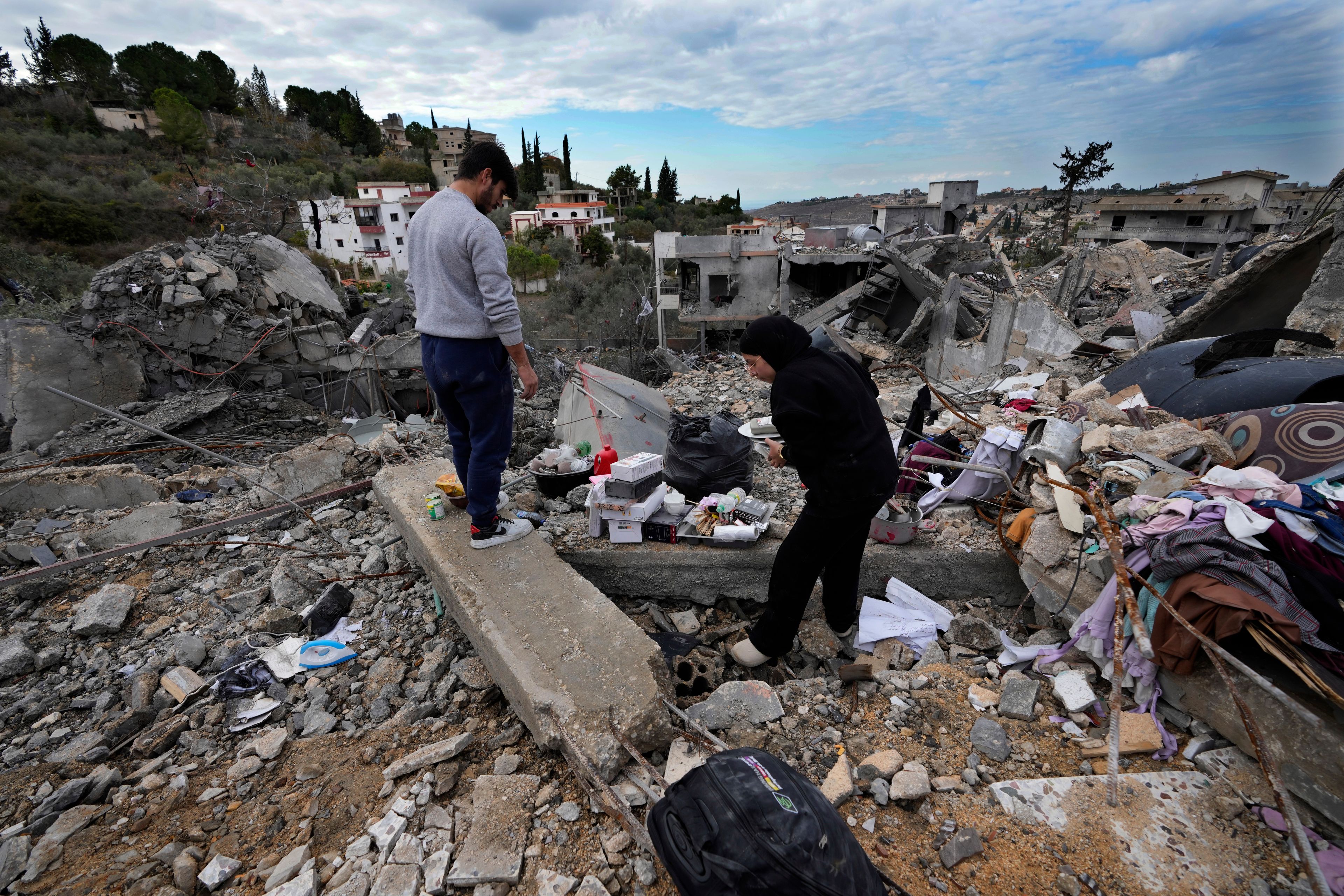 Residents collect personal remains from their destroyed house after they returned to Chehabiyeh village, southern Lebanon, Thursday, Nov. 28, 2024 following a ceasefire between Israel and Hezbollah that went into effect on Wednesday.(AP Photo/Hussein Malla)