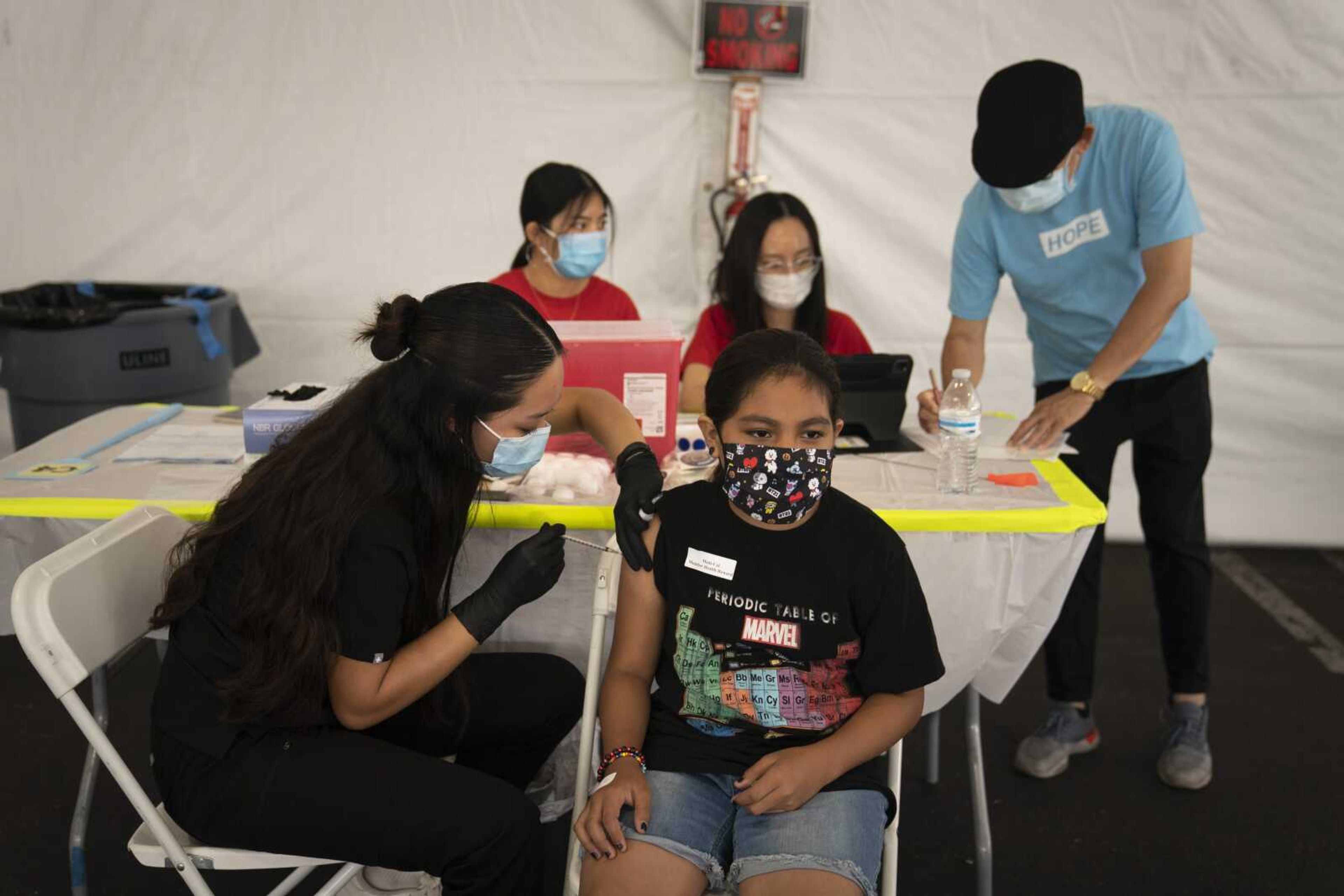 Mayra Navarrete, 13, receives the Pfizer COVID-19 vaccine from registered nurse Noleen Nobleza at a clinic set up in the parking lot of CalOptima on Aug. 28 in Orange, California.