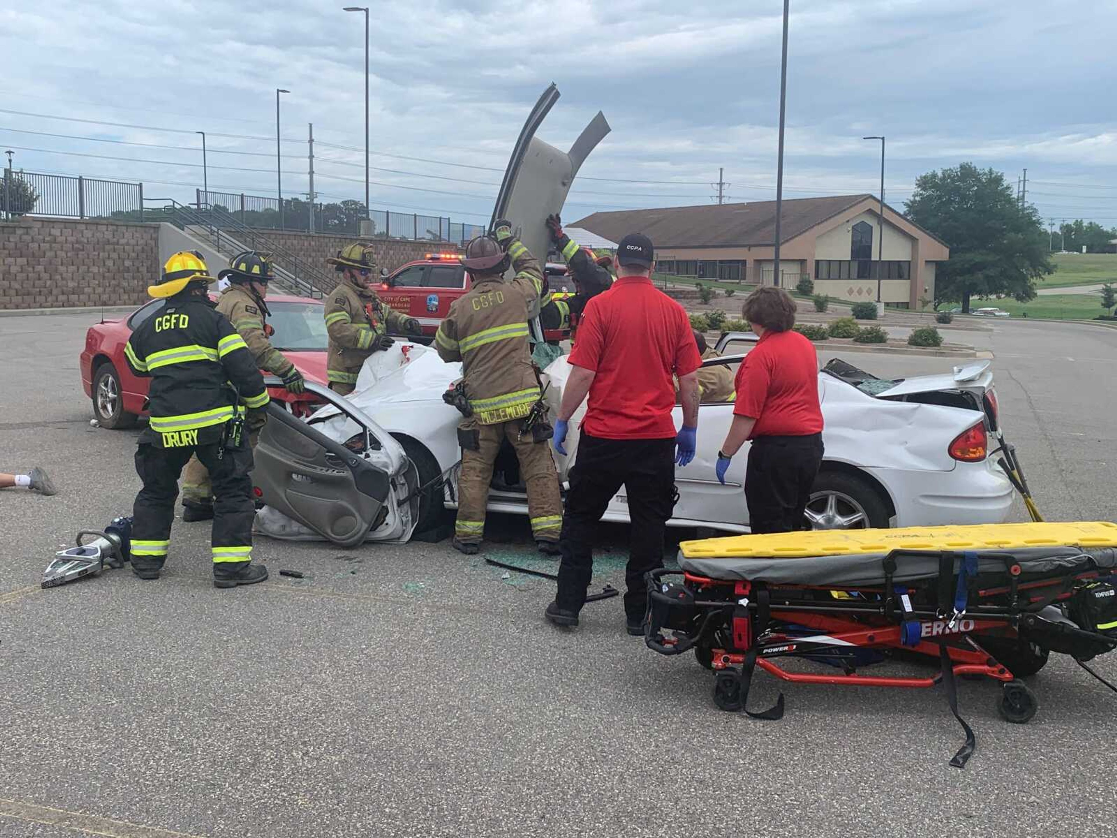 Firefighters from CGFD remove the roof of the vehicle as emergency medical technicians (EMT) from Cape County Private Ambulance service await to place the driver of the vehicle on a stretcher.&nbsp;