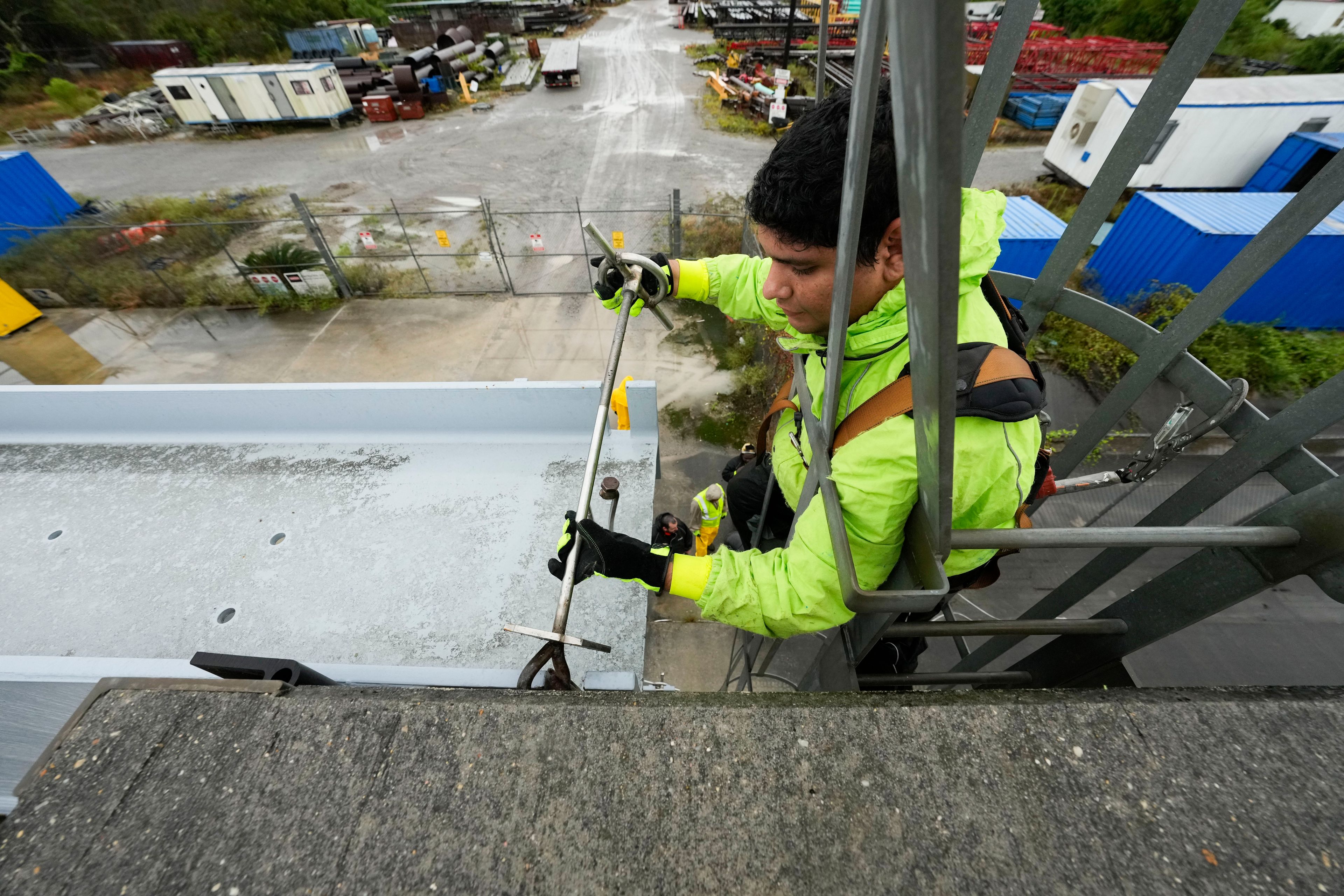 Delwyn Bodden, a worker for the Southeast Louisiana Flood Protection Authority-West climbs a ladder up a floodgate to lock it closed along the Harvey Canal, just outside the New Orleans city limits, in anticipation of Tropical Storm Francine, in Harvey, La., Tuesday, Sept. 10, 2024. (AP Photo/Gerald Herbert)