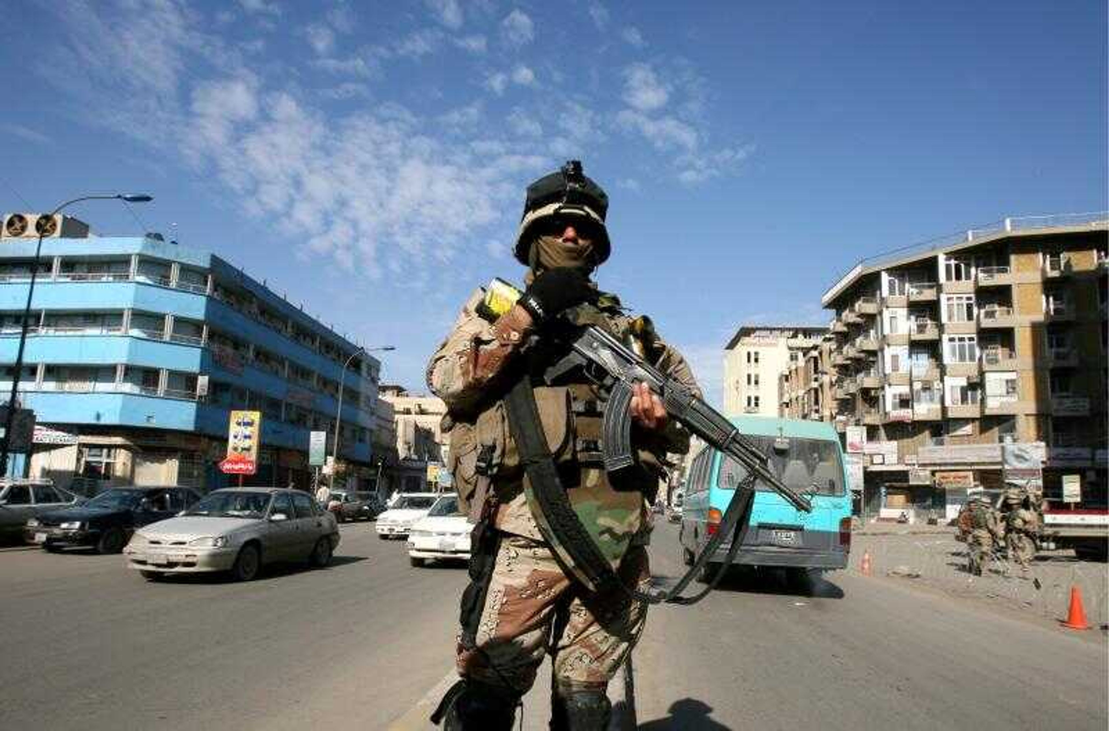 An Iraqi army soldier controlled traffic on a street in central Baghdad, Iraq, on Friday.  Iraqi forces intensified their patrols and put up new checkpoints on the streets of Baghdad, as the long-awaited new security operation &#8212; which will involve about 90,000 Iraqi and American troops and is seen by many as a last chance to curb Iraq's sectarian war &#8212; is underway in Baghdad. (KHALID MOHAMMED ~ Associated Press)