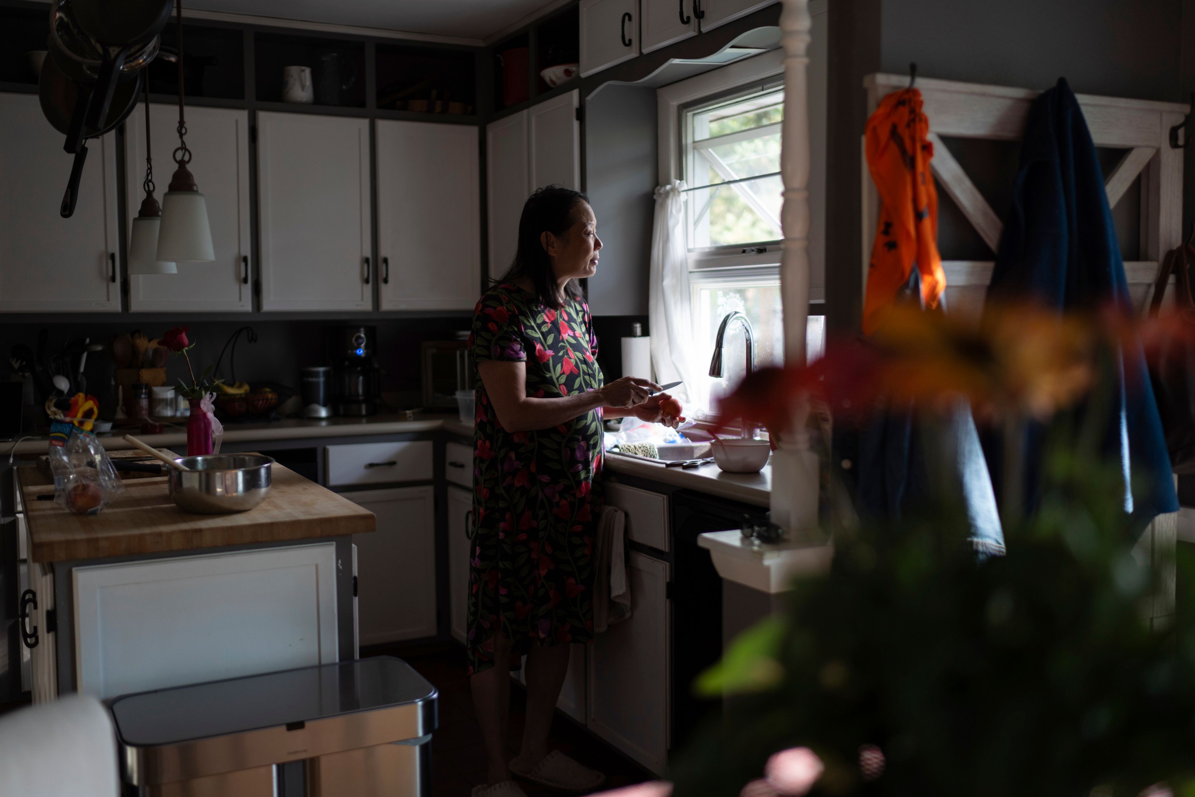 Lesley Dzik looks out her kitchen window, in Champaign, Ill., Saturday, Sept. 21, 2024. Lesley is deeply Christian. Matt, her husband sees himself as more spiritual than religious. "I get worried with Matt because I believe the Bible is truth and Matt is iffy about that," she said. "I wonder what I got myself into." (AP Photo/David Goldman)