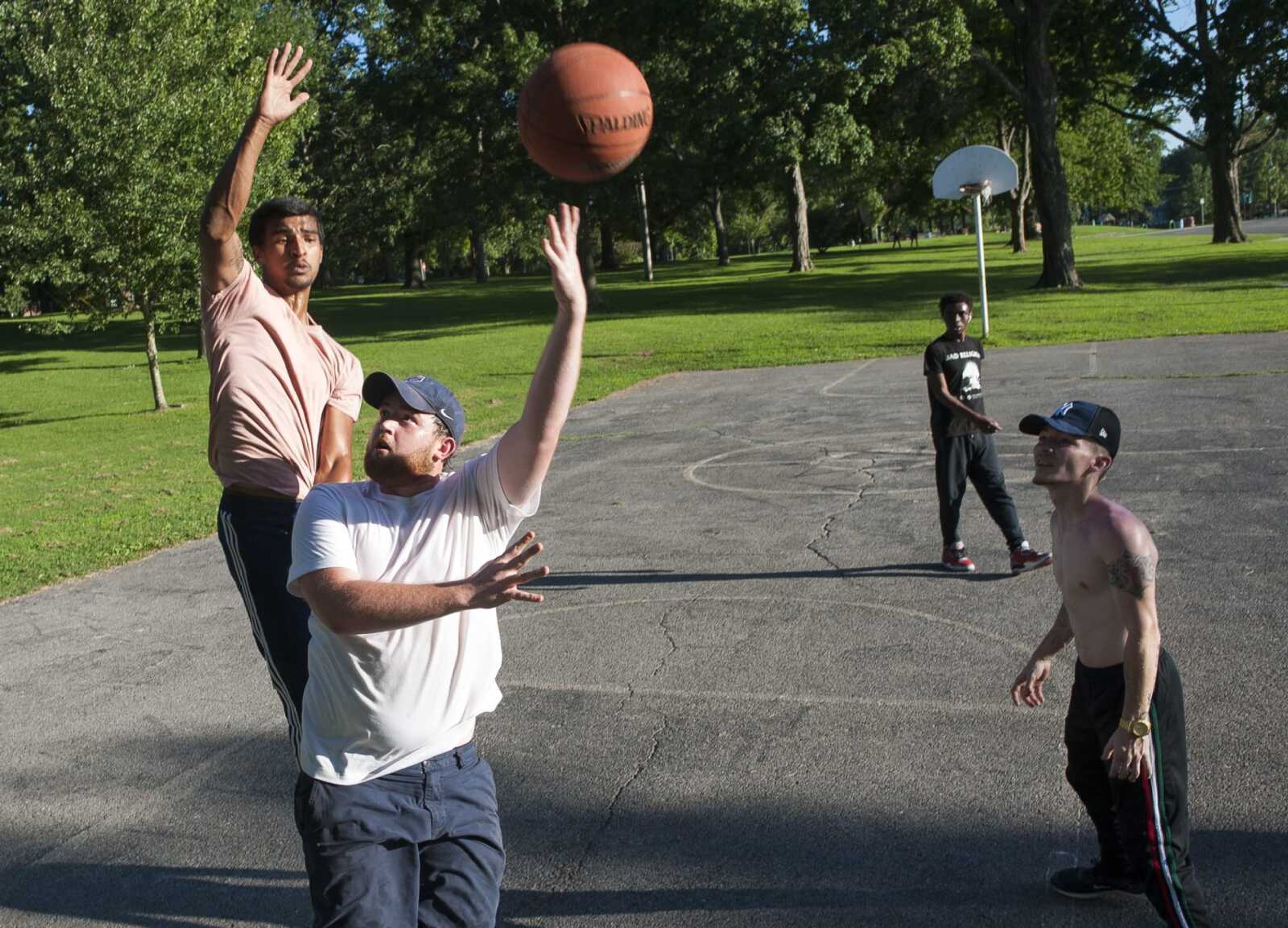 Nathan Parker, below left, puts up a hook shot as Bradley Brooks, above left, plays defense during a pick-up  basketball game Sunday at Capaha Park in Cape Girardeau.