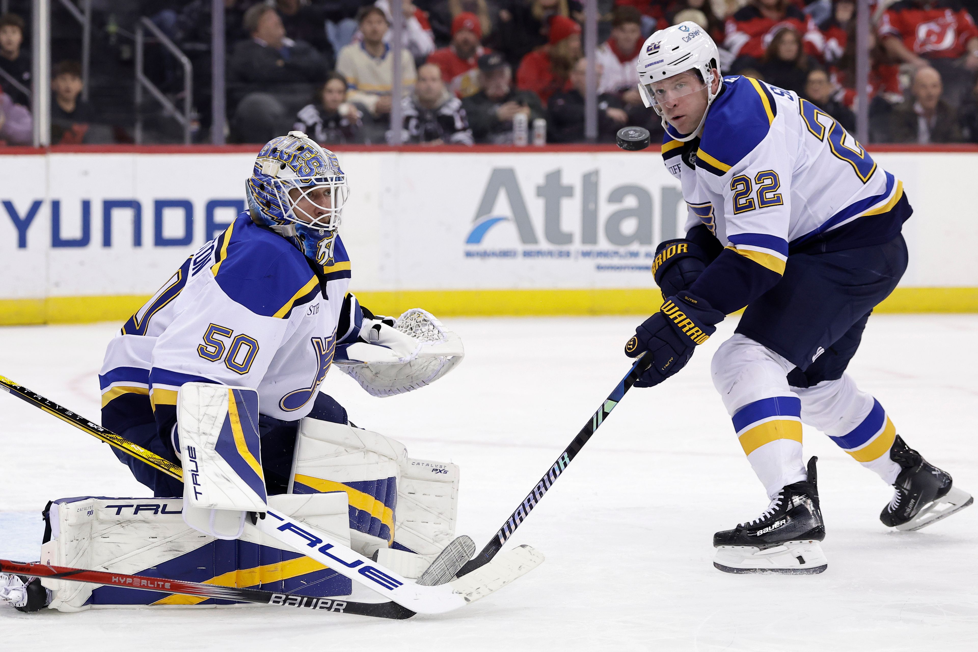 St. Louis Blues goaltender Jordan Binnington and Ryan Suter (22) watch the puck go past during the second period of an NHL hockey game against the New Jersey Devils Wednesday, Nov. 27, 2024, in Newark, N.J. (AP Photo/Adam Hunger)