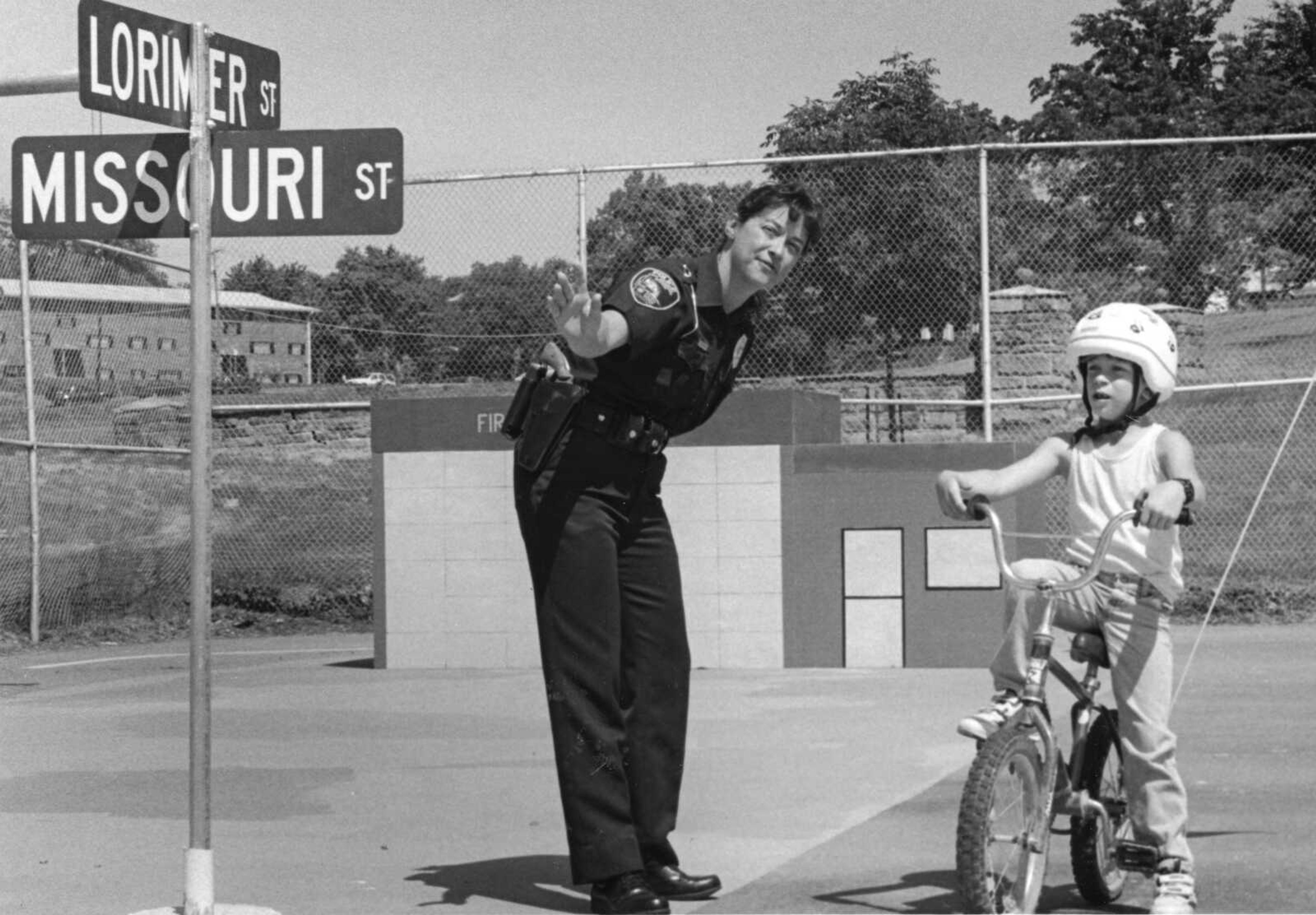 Cape Girardeau police officer Jeannie Dailey instructs Travis Smith, 9, on the rules of bicycle safety at the Safety Village in Missouri Park. A bicycle rodeo was held to promote bicycle safety. Bicycle safety checks were provided. (Published May 17, 1993)