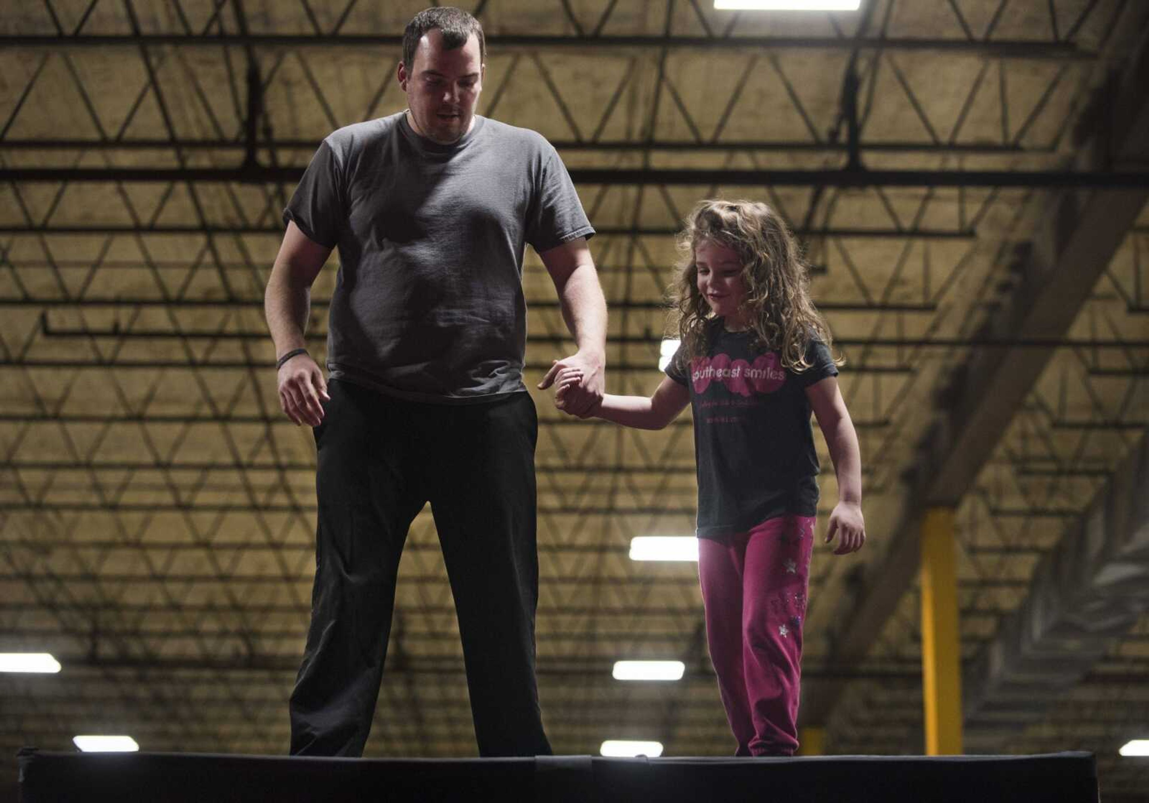 Zach Martin holds hands with his daughter, Skylar, 5, before jumping into a pit of foam blocks Tuesday, Feb. 13, 2018, during an Easterseals Midwest monthly outing at Ultimate Air Trampoline Park in Scott City.