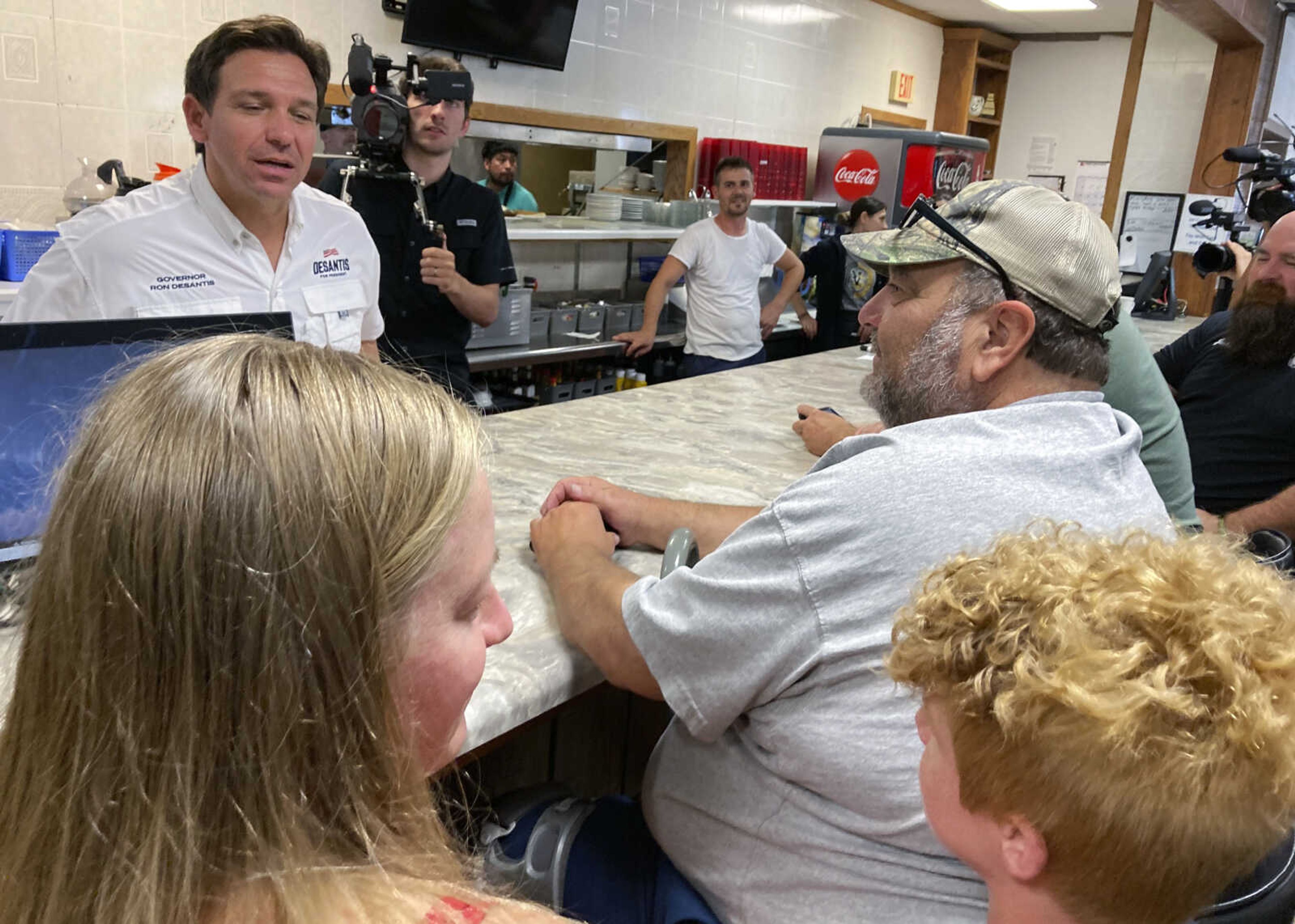 Republican presidential candidate Florida Gov. Ron DeSantis talks to 11-year-old Jackson Ingraham of Vinton, Iowa, while meeting voters at Vinton Family Restaurant on Saturday in Vinton. DeSantis was on a two-day trip across Iowa.