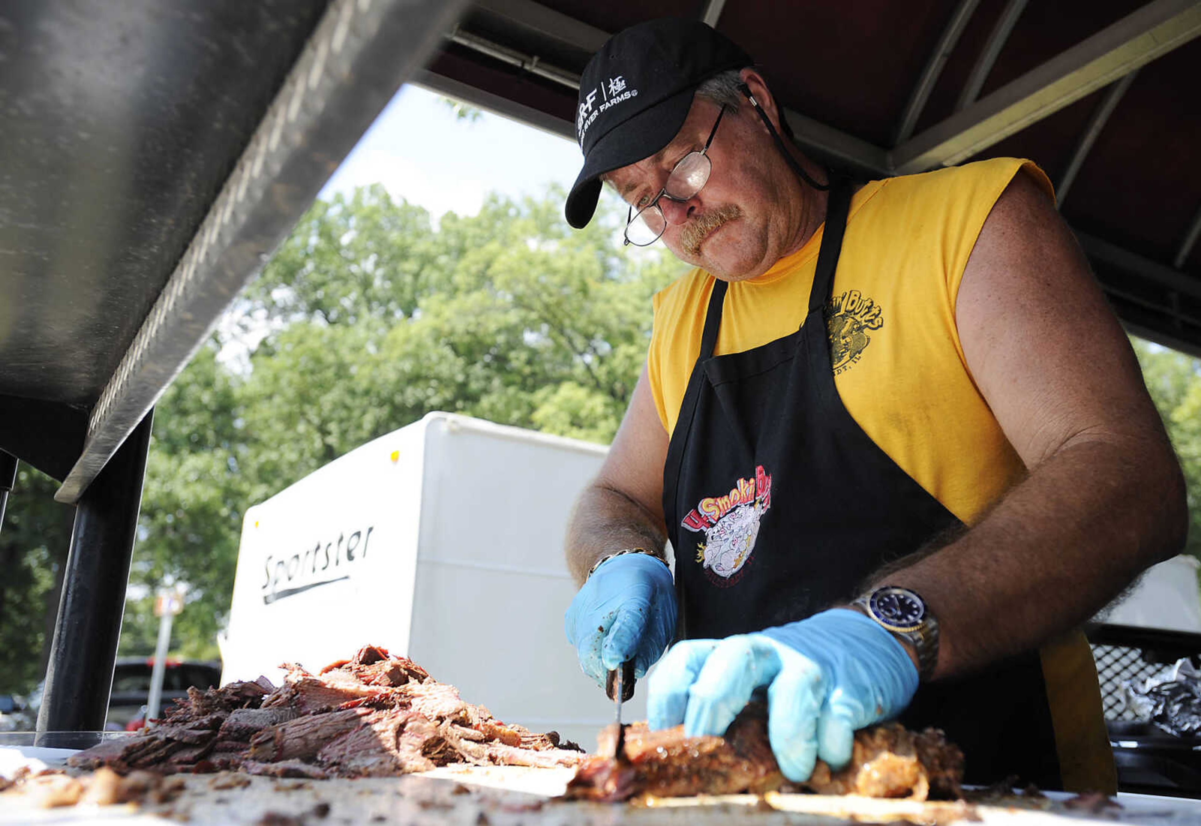 Dennis Keck, of the 4 Smokin Butts team, slices brisket during the 21st annual Cape BBQ Fest Saturday, Aug. 24, at Arena Park in Cape Girardeau. Fifty-seven teams competed in the event which is sanctioned by the Kansas City Barbecue Society and sponsored by the Jaycees.