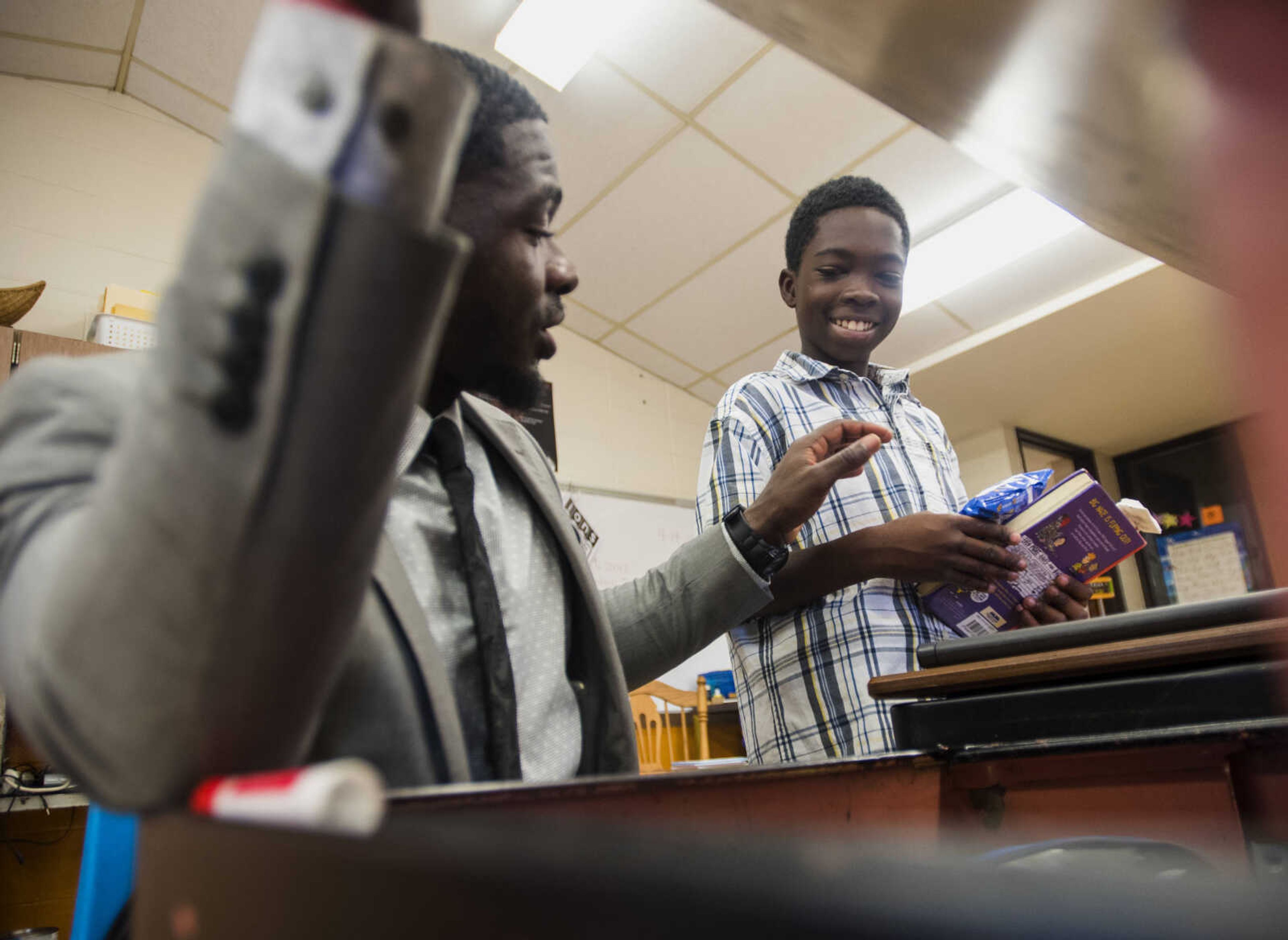 Honorable Young Men's Club leader Cantrell Andrews, left, teaches Lemuel Gilbert, 11, to keep his desk tidy Sept. 19, 2017 at Central Middle School in Cape Girardeau.