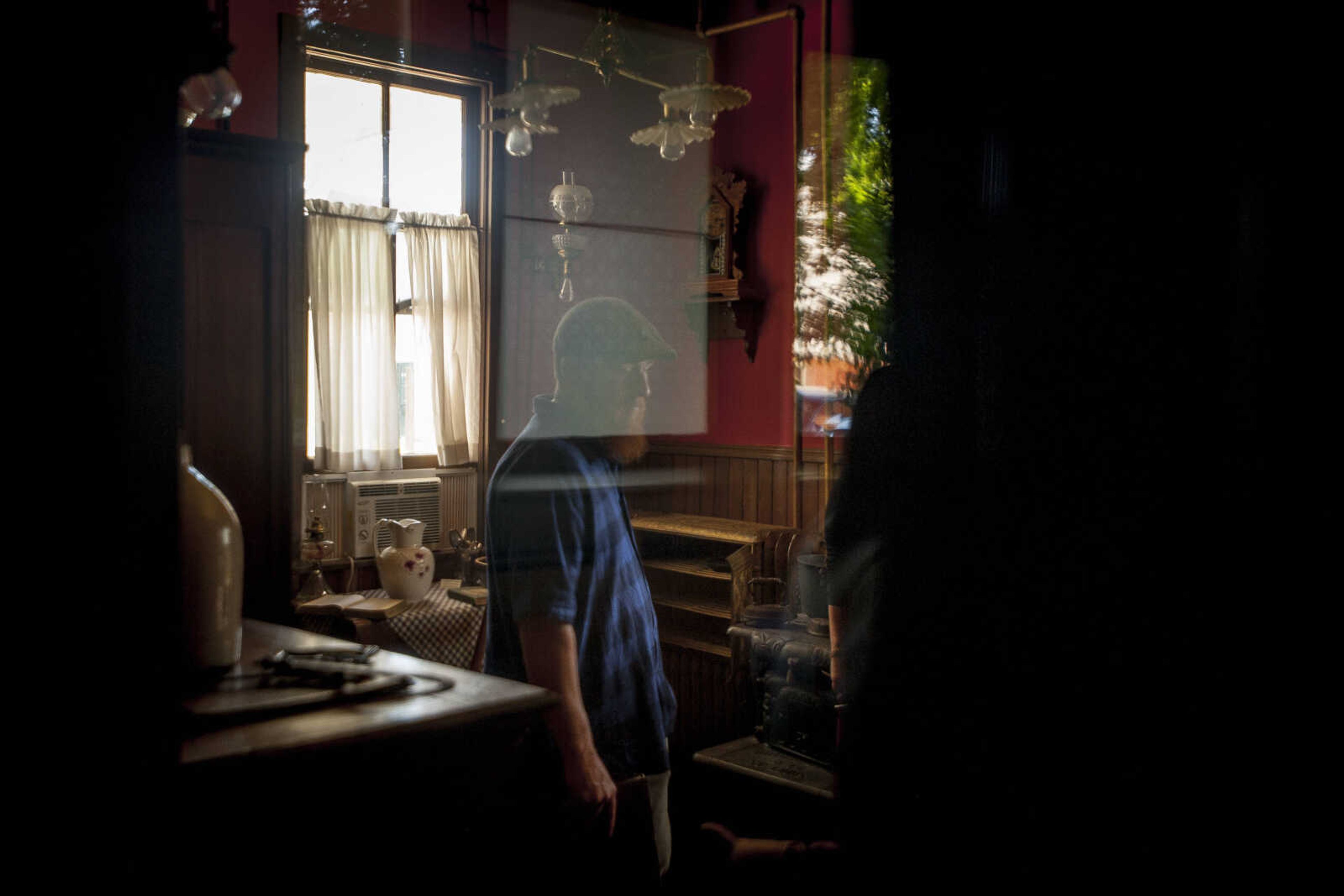 Caretaker Josh Hepler is seen in the kitchen near an air-conditioning unit, dehumidifier and antique wood stove  Thursday, June 13, 2019, at the Glenn House in Cape Girardeau.