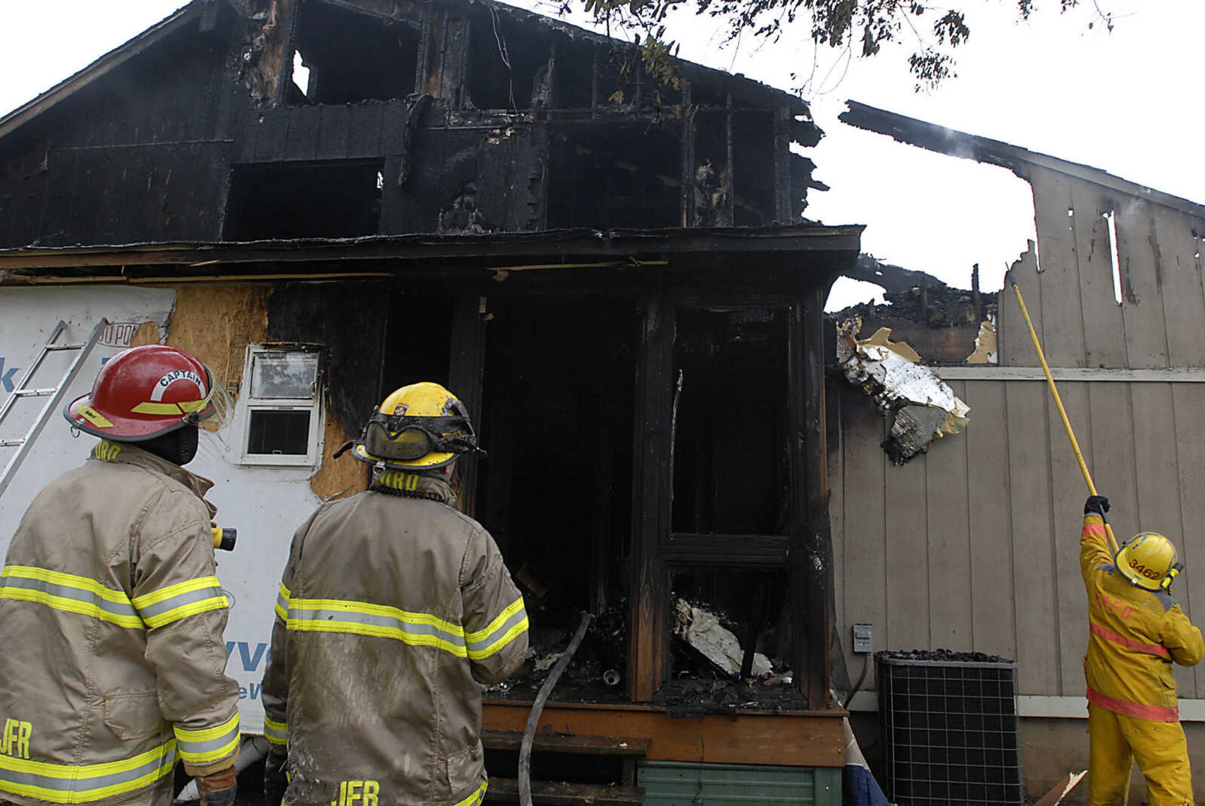 KIT DOYLE ~ kdoyle@semissourian.com
Area firefighters clear areas of the Ladd home following a blaze Friday, October 16, 2009, north of Jackson on Big Cone Lane.