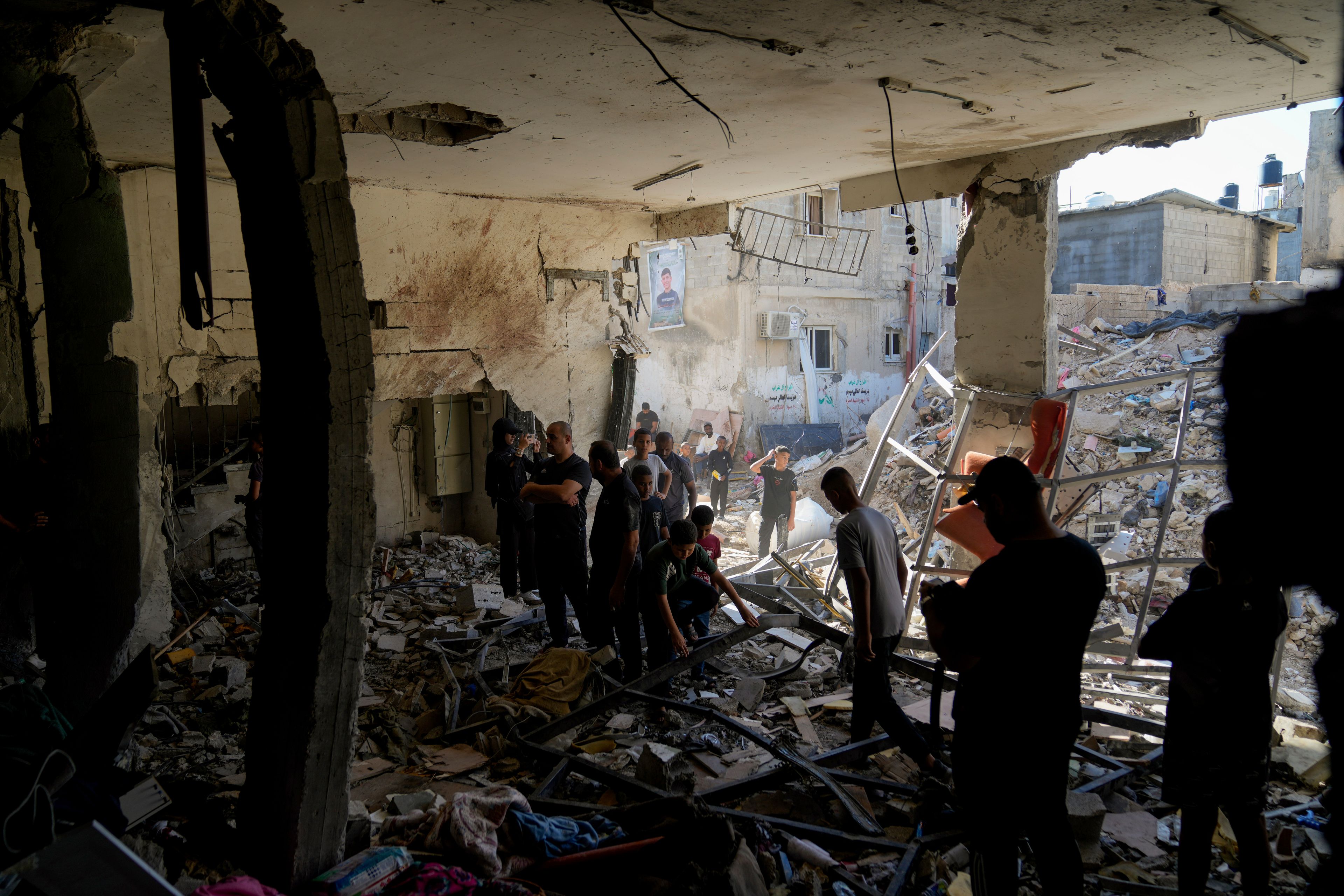 Palestinians examine the damage following an Israeli airstrike in the West Bank city of Tulkarem, which Palestinian health officials say killed 18 people and the Israeli military says took out a Hamas leader, on Friday, Oct. 4, 2024. (AP Photo/Nasser Nasser)