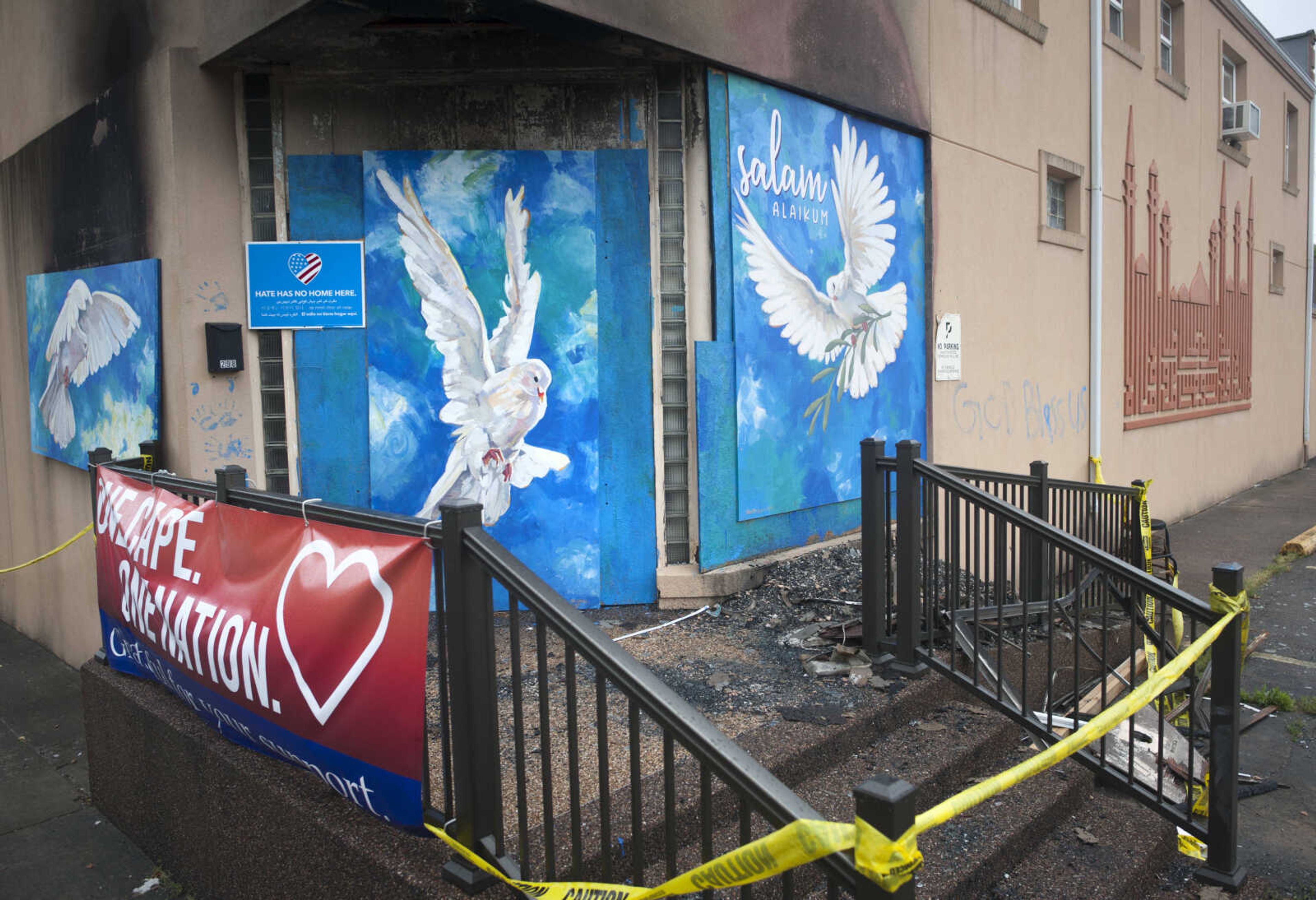 Artwork created by local artists Christy Moore and Craig Thomas hangs over burnt sections of the Islamic Center of Cape Girardeau on Sunday, May 17, 2020 about four weeks after an arsonist set fire to the facility on the first morning of Ramadan.