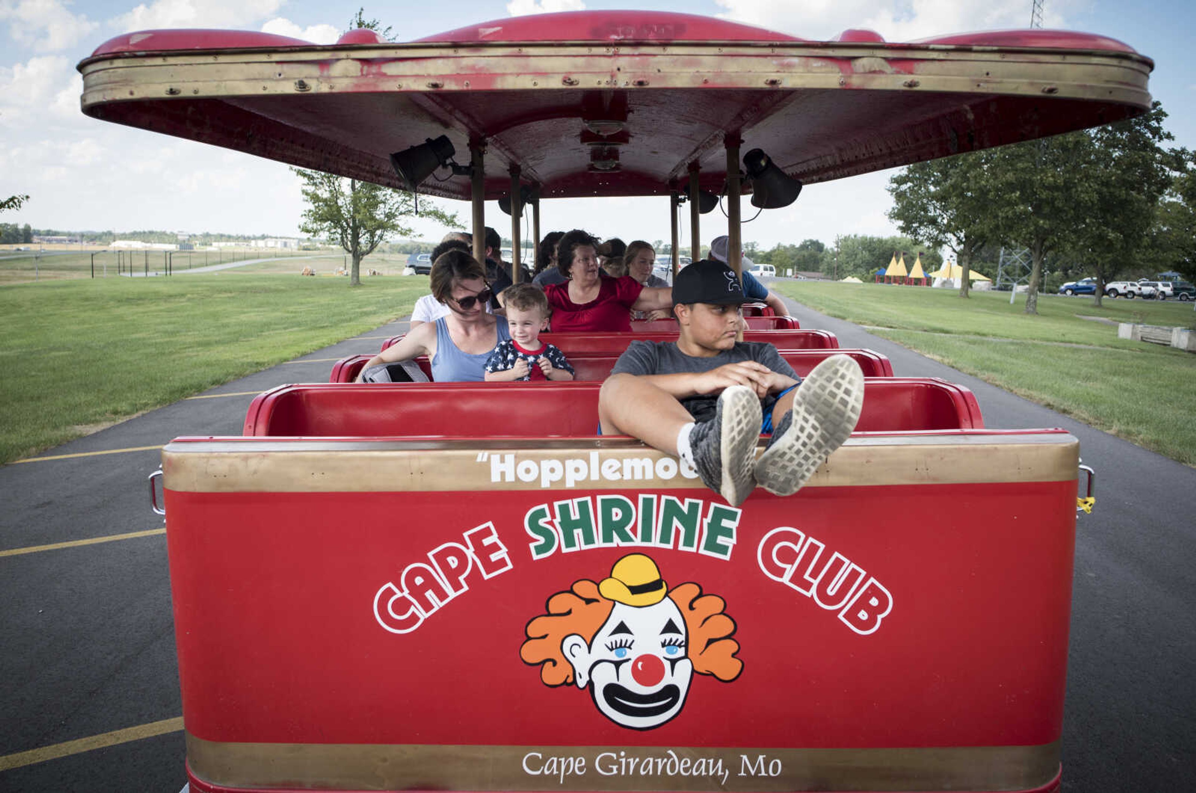 Keestin Brandy, 12, of Jackson, rests his feet while riding in front of Haley Hawkins and her 1-year-old son Beckham, center left, aboard the Cape Shrine Club's "Hopplemobile" on Sept. 29, 2019, at Cape County Park North.