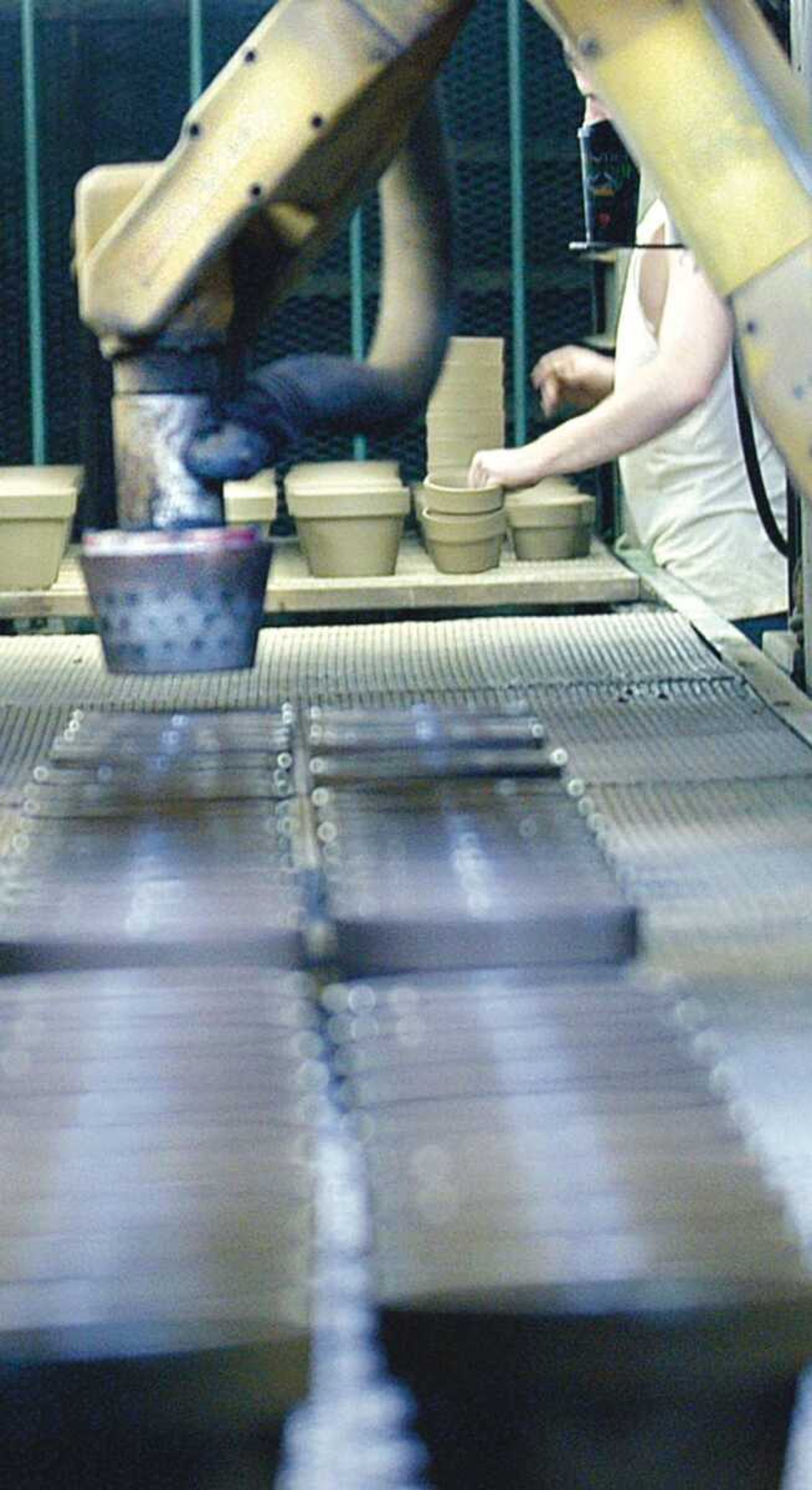 An employee of Ceramo worked side by side with the robotic arm making clay pots Monday. (Diane L. Wilson)