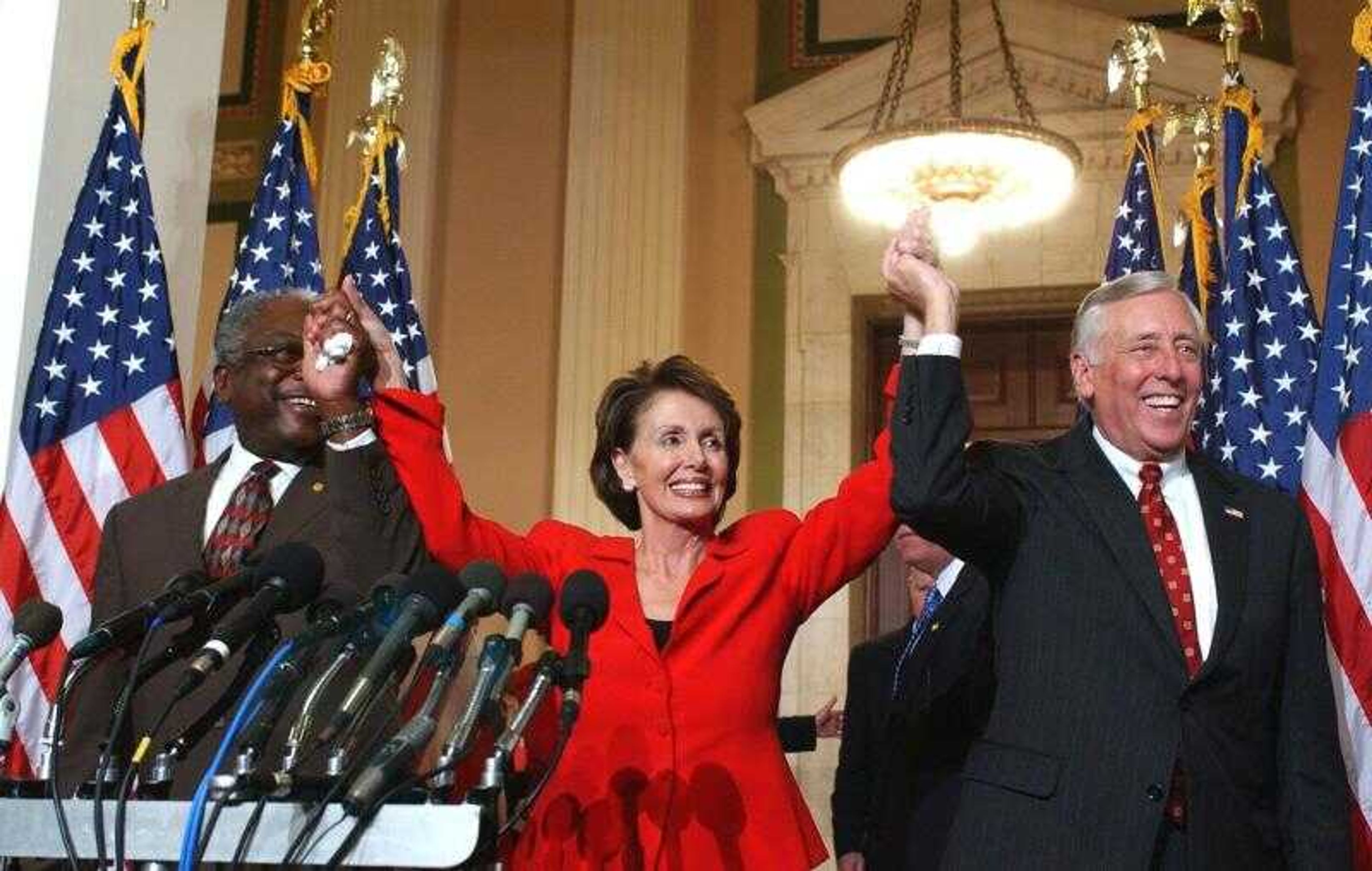 Incoming House Speaker Nancy Pelosi of Calif., center, raised her arms with incoming House Majority Leader Steny Hoyer of Maryland, right, and incoming House Majority Whip James Clyburn of South Carolina during a news conference on Capitol Hill in Washington, D.C., Thursday where the new Democratic House leadership was announced.