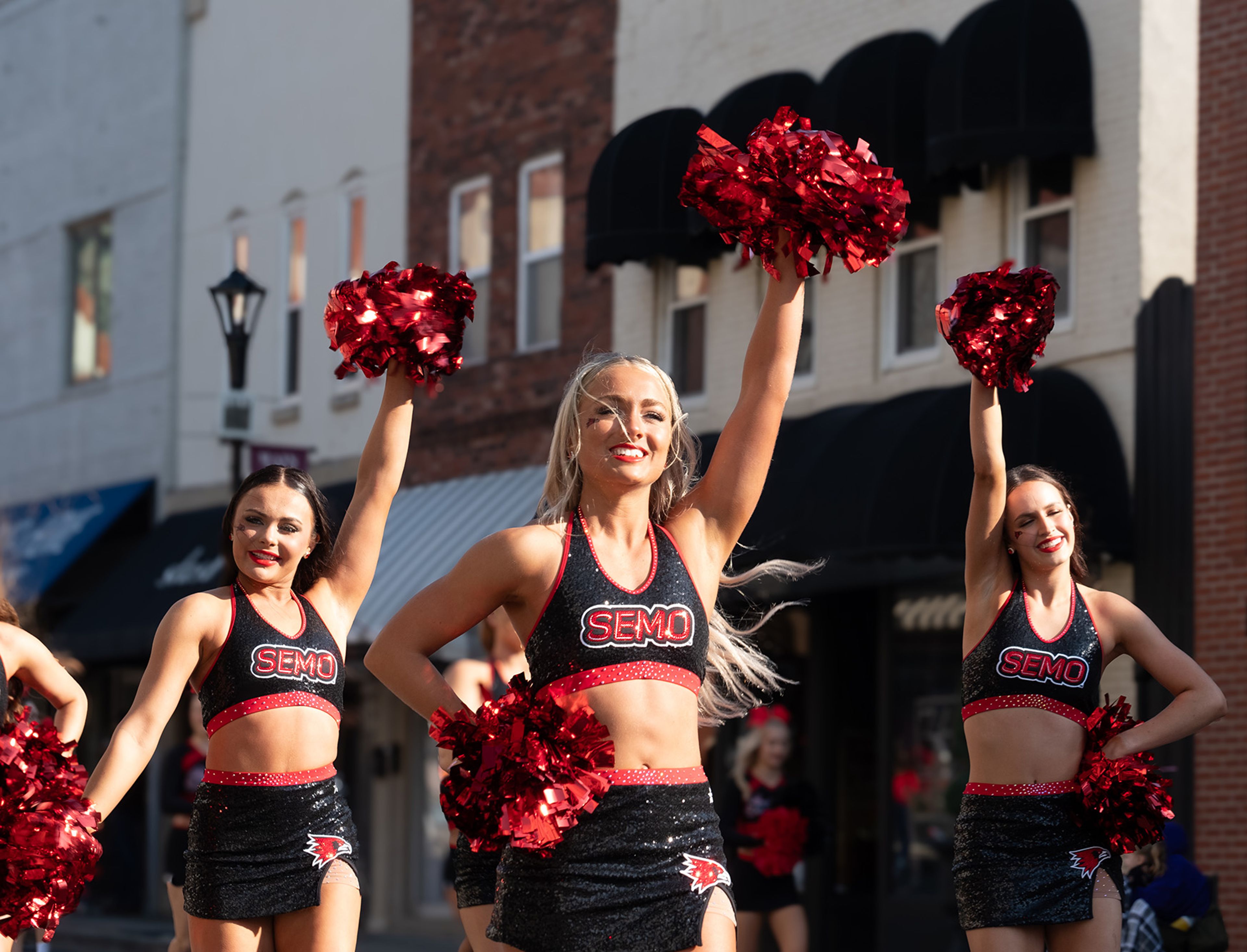 SEMO Sundancers, from left, Jaclyn Sexauer from Columbia, Rachel Saferite from Chesterfield and Abigail Grover from Lake Charles cheer together during the parade.
