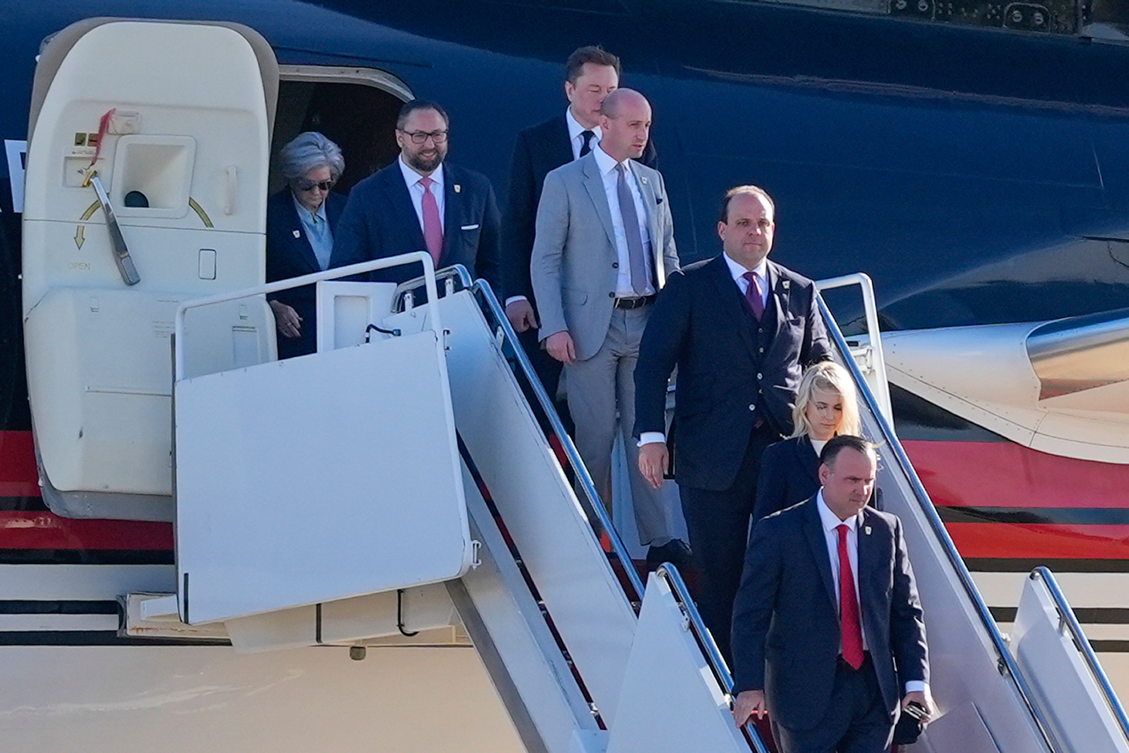 From l-r., Susie Wiles, Jason Miller, Elon Musk, Stephen Miller, Boris Esphteyn, Natalie Harp and Dan Scavino, walk off President-elect Donald Trump's as he arrives, Wednesday, Nov. 13, 2024, at Andrews Air Force Base, Md. (AP Photo/Alex Brandon)