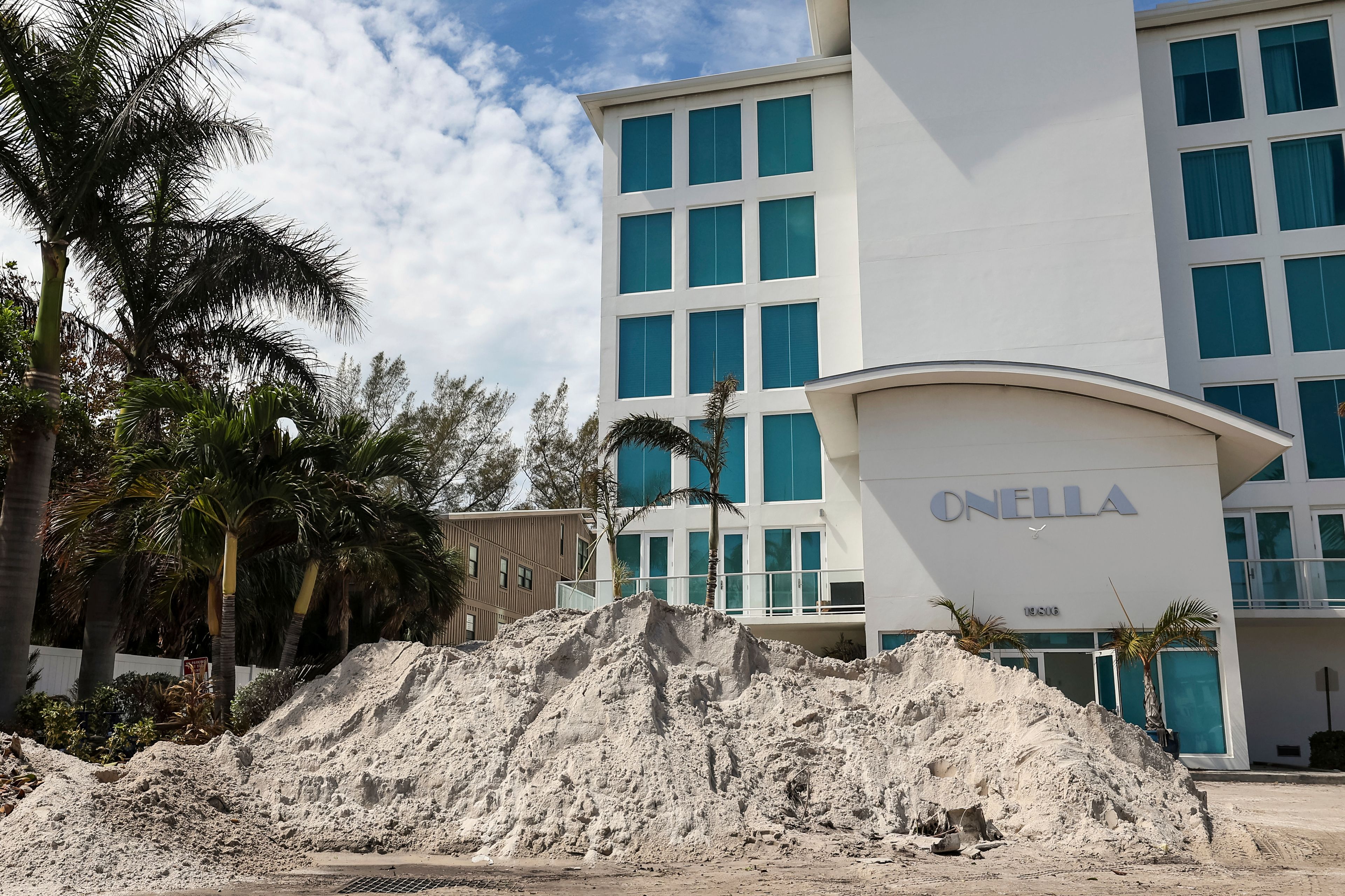 Crews continue to clean up sand caused by the flooding in Hurricane Helene on Gulf Boulevard on Wednesday, Oct. 2, 2024, in Indian Rocks Beach, Fla. (AP Photo/Mike Carlson)