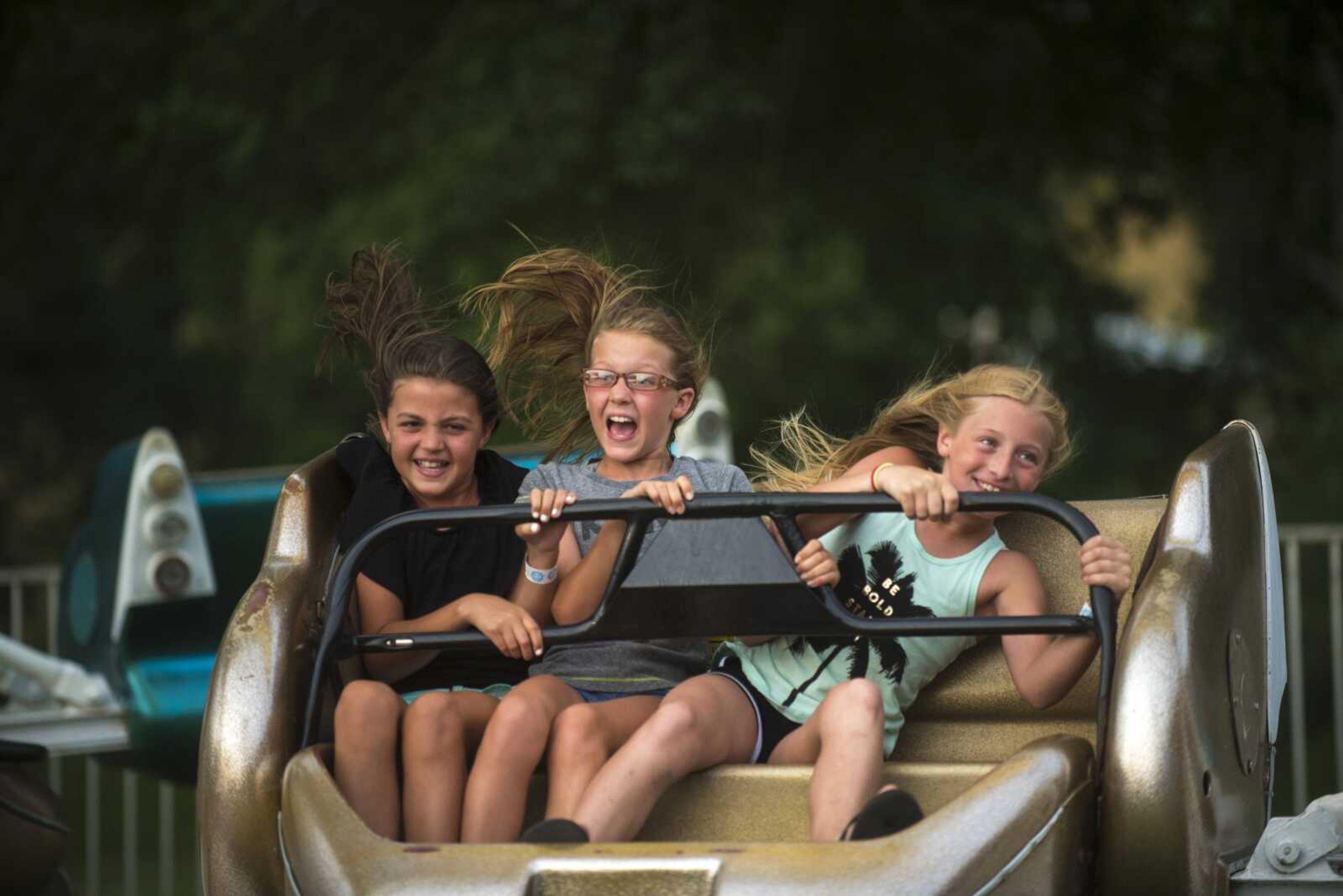 Kids hold on while on an amusement ride during the 41st annual Mid-Summer Festival on June 16, 2017, at Scott City Park.