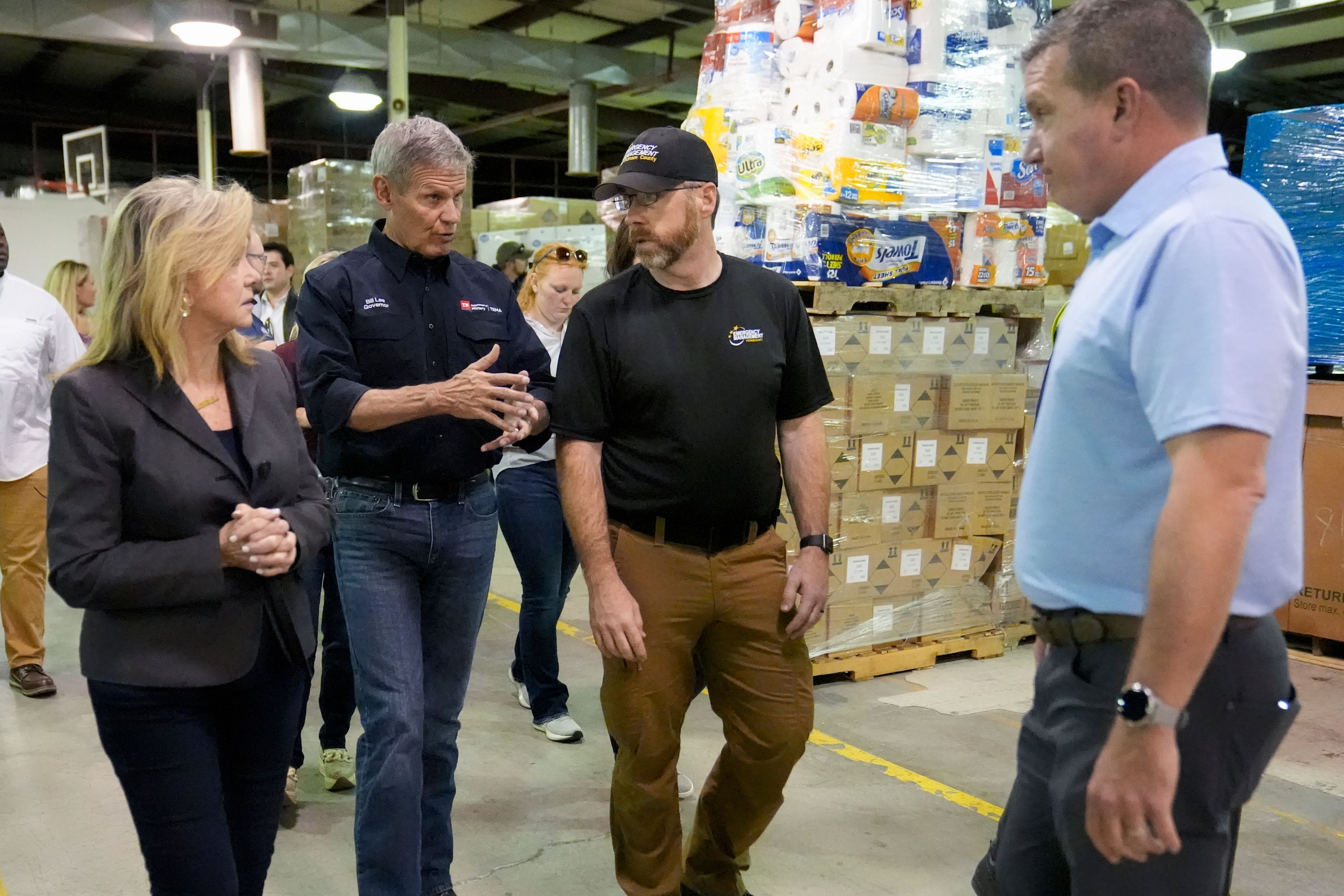 Sen. Marsha Blackburn, left, and Tennessee Gov. Bill Lee, second from the left, speak with Brandon Smith of the Putnam County EMA and Jerry Caldwell general manager of Bristol Motor Speedway, right, as they visit the East Tennessee Disaster Relief Center, for Hurricane Helene disaster response Monday, Oct. 7, 2024, in Bristol, Tenn. (AP Photo/George Walker IV via Pool)