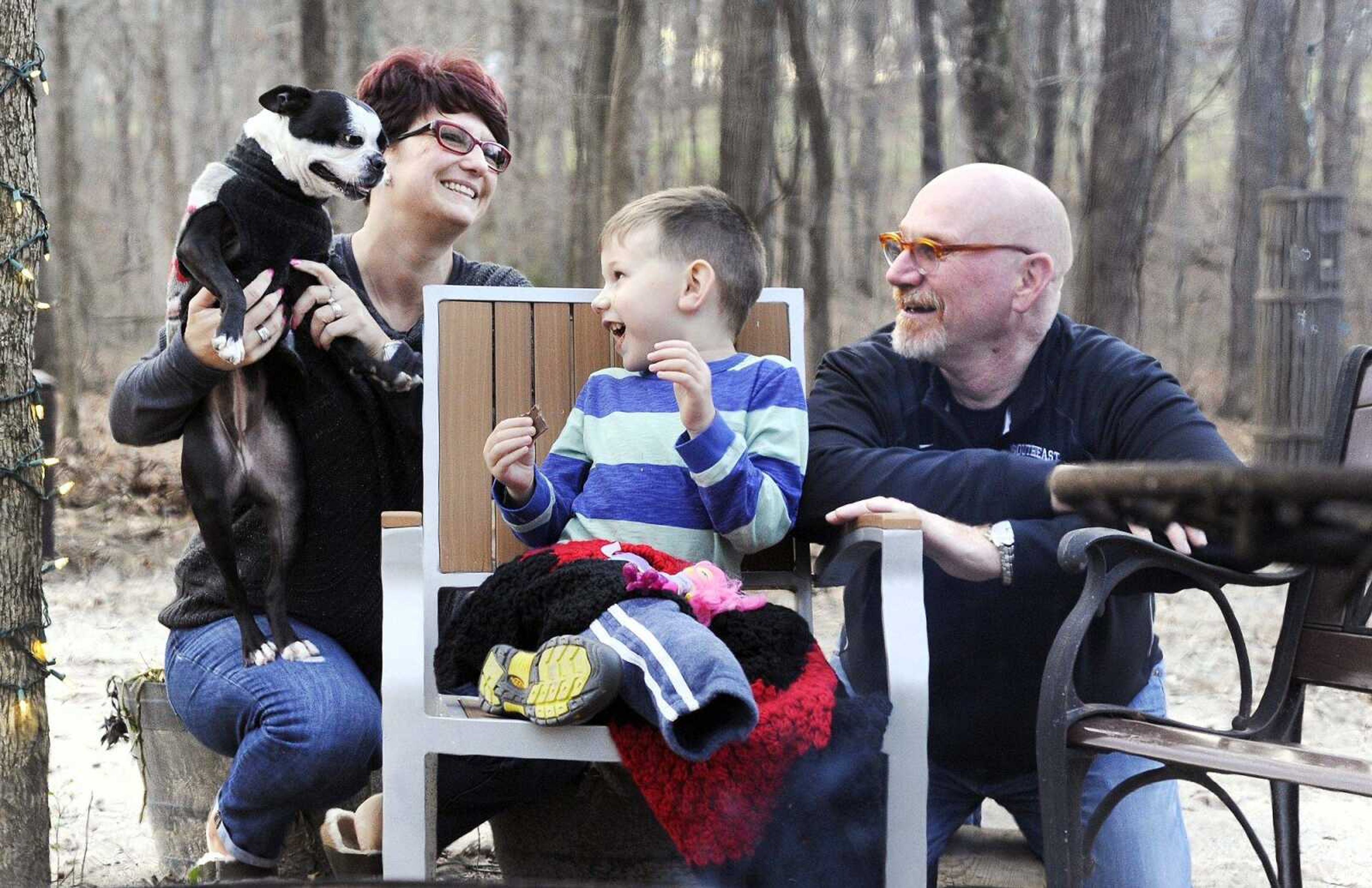 Declan Stevens munches on the chocolate from a s'more Tuesday while surrounded by his parents Vanessa and Brian, and family dog, Millie. (Laura Simon)