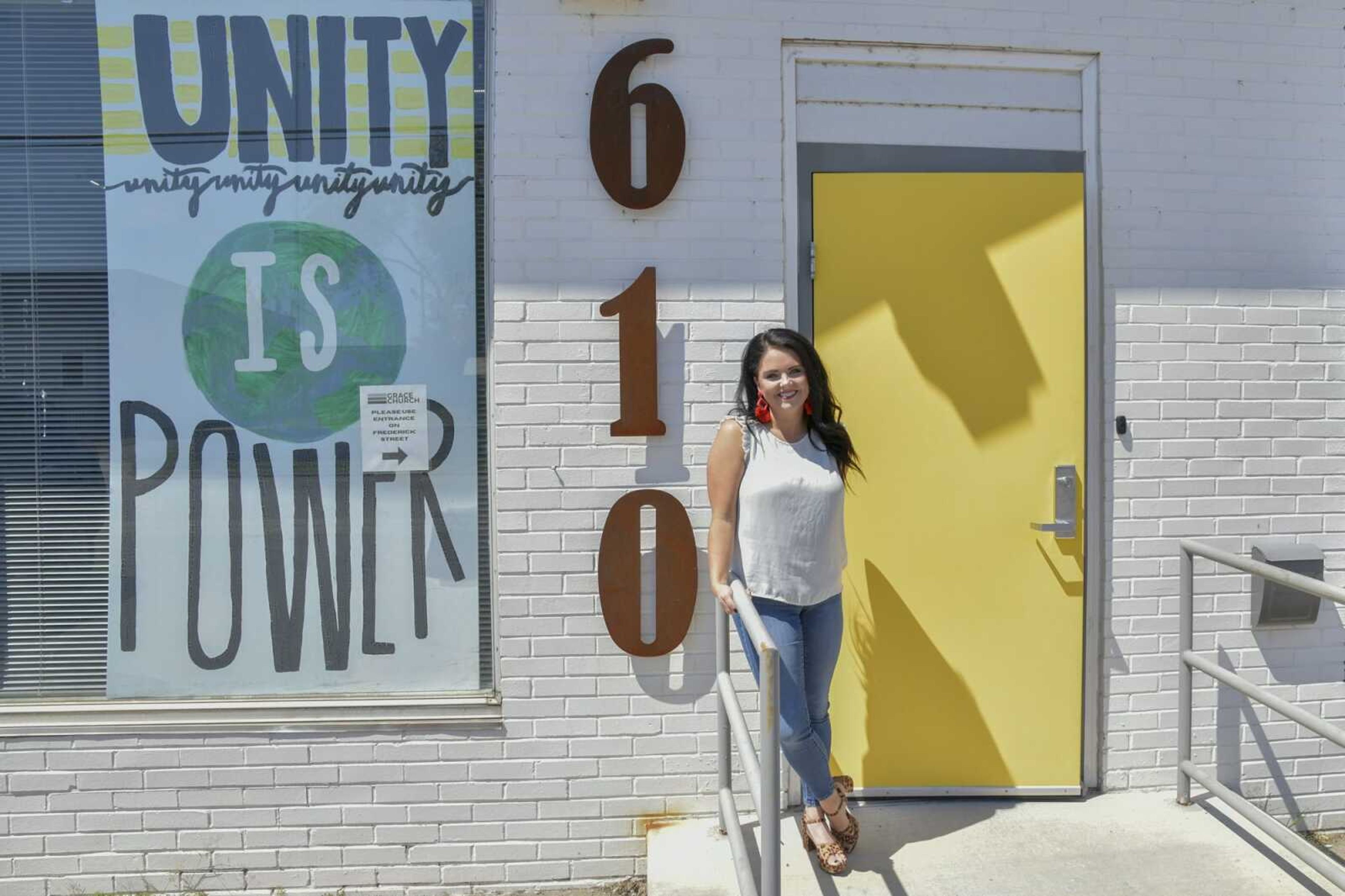 Taylor Smith, the new executive director of One City, poses for a portrait near the organization's signature yellow door Wednesday at One City in Cape Girardeau.