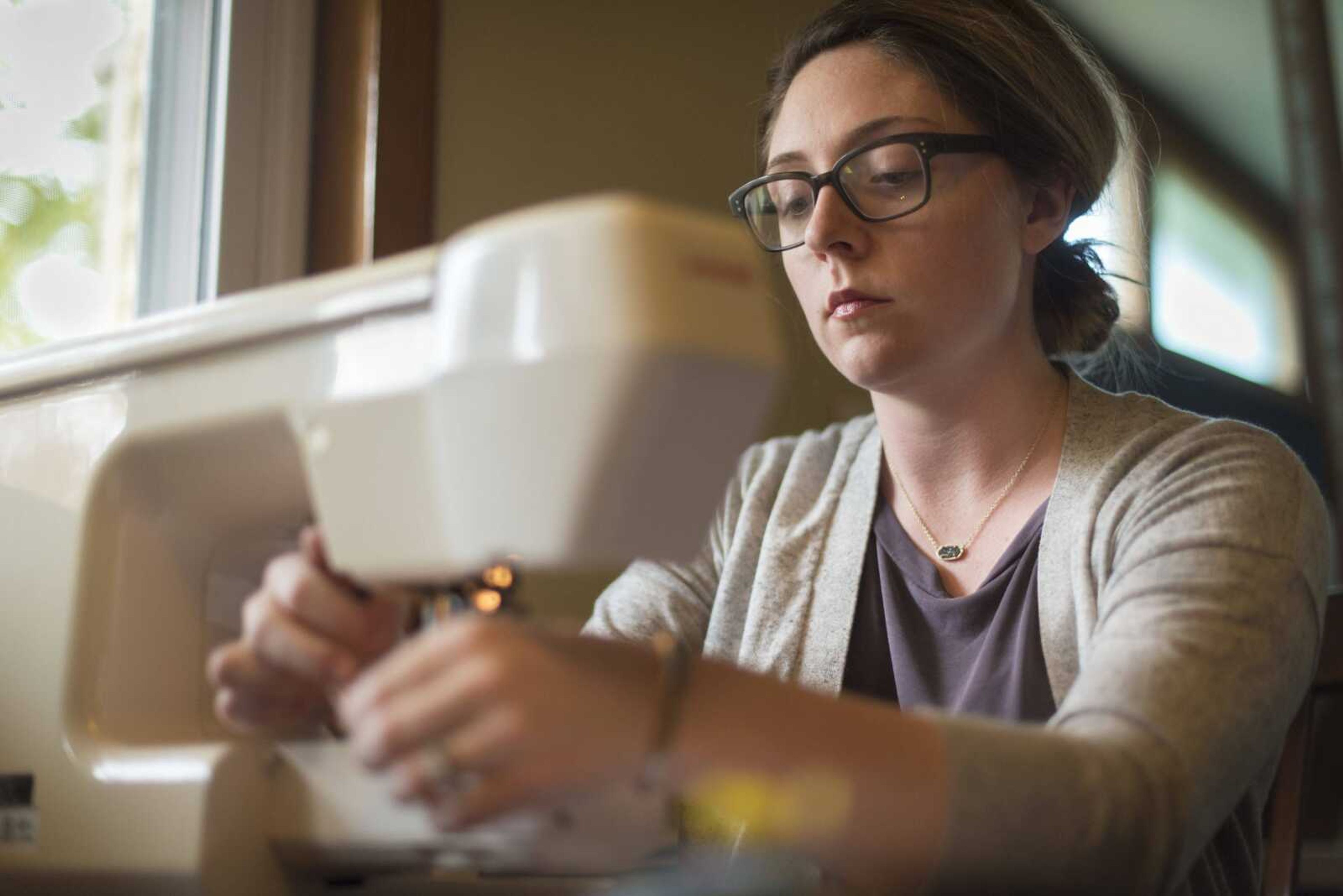 Fashion description:Emily Colbert works on her grandmother's sewing machine in her kitchen.