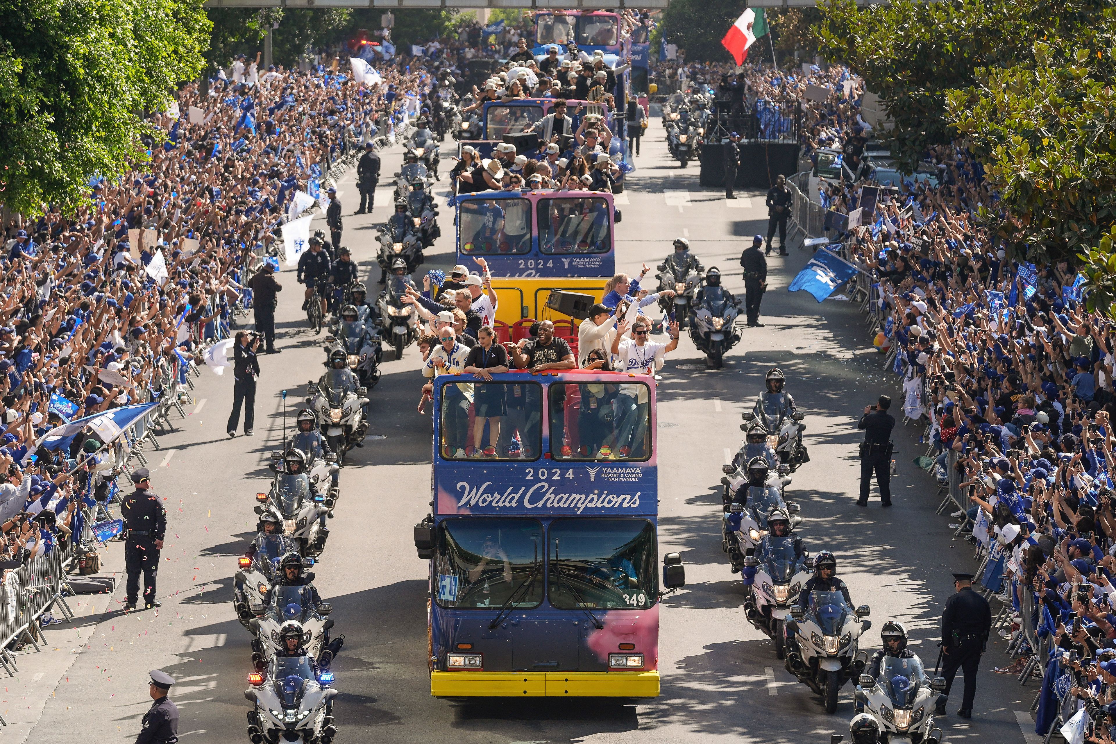 Los Angeles Dodgers players, coaches and ownership group are paraded on buses during the baseball team's World Series championship parade Friday, Nov. 1, 2024, in Los Angeles. (AP Photo/Damian Dovarganes)