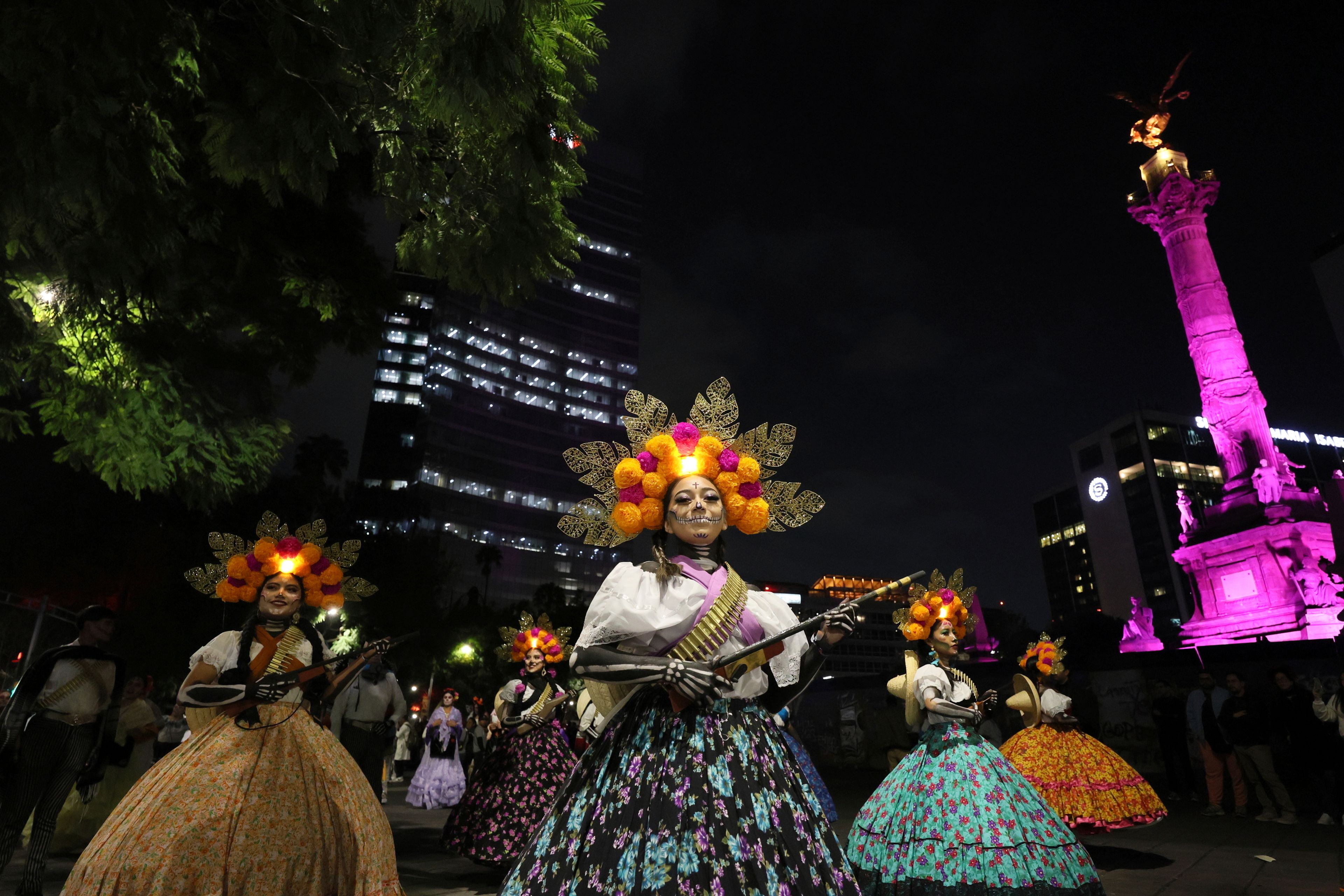 People dressed as "Catrinas" parade through the streets during celebrations ahead the Day of the Dead in Mexico City, Sunday, Oct. 27, 2024. (AP Photo/Ginnette Riquelme)