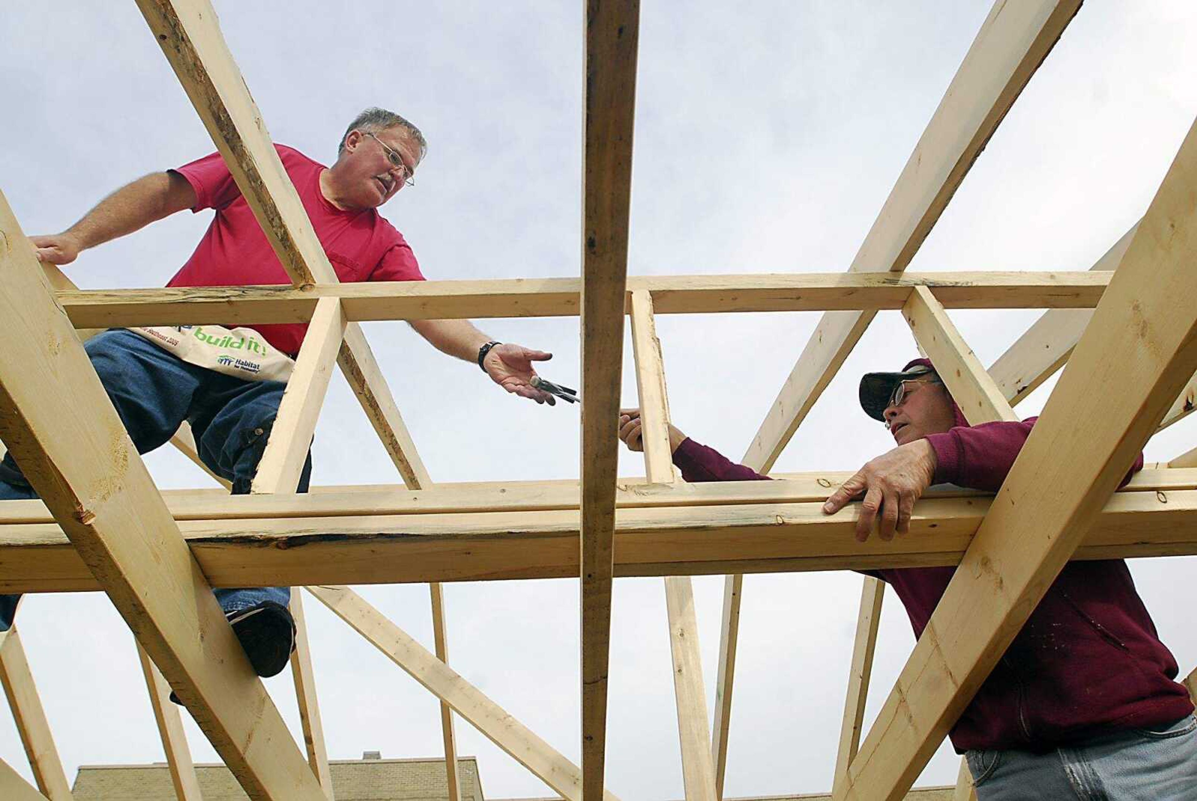 KIT DOYLE ~ kdoyle@semissourian.com
Dave Sanders, left, and Loren Winterhof share a hammer while securing rafters in thehe Habitat for Humanity home being built in the Alumni Center parking lot Friday, March 13, 2009, in Cape Girardeau.