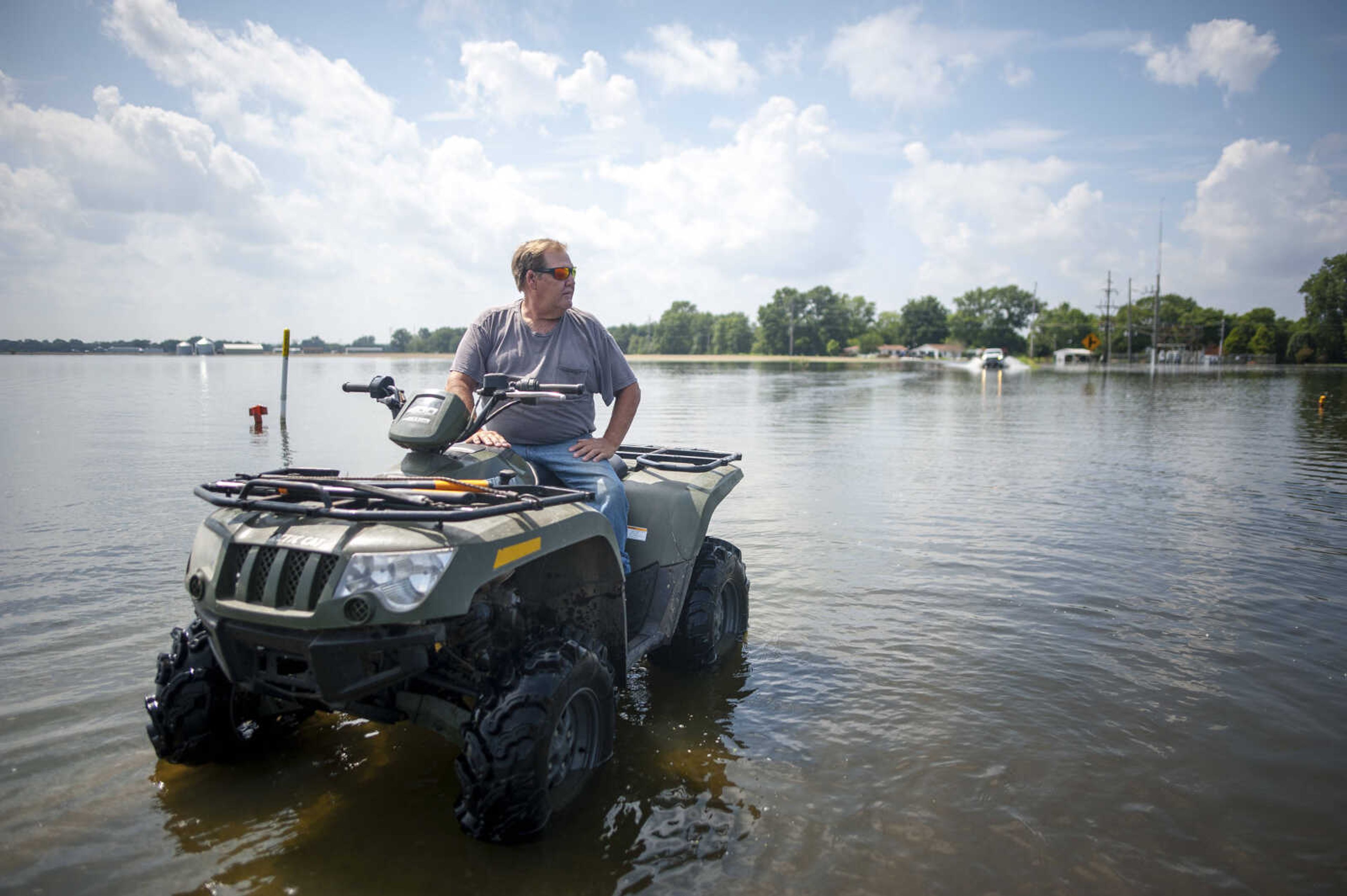 Rick Myers waits for a truck to pass on a flooded stretch of road Saturday, July 6, 2019, in McClure. Myers said most people drive too fast through floodwaters and often leave wakes that can undermine levees around houses that would otherwise hold up. "Some people are courteous about it, but others of them, not so much," he said.