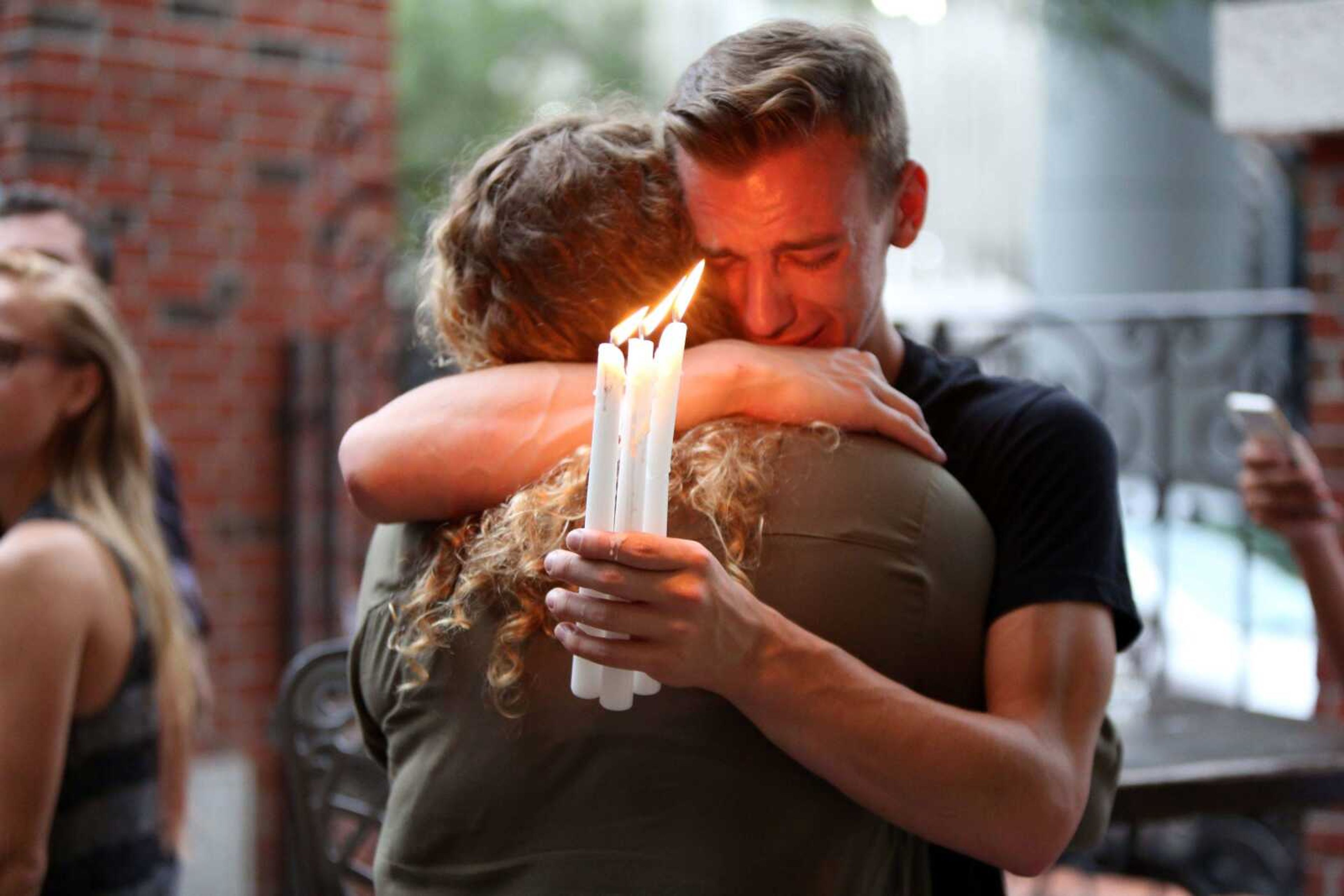 Brett Morian hugs a fellow mourner June 12 during a candlelight vigil for those killed at the Pulse nightclub in Orlando, Florida.