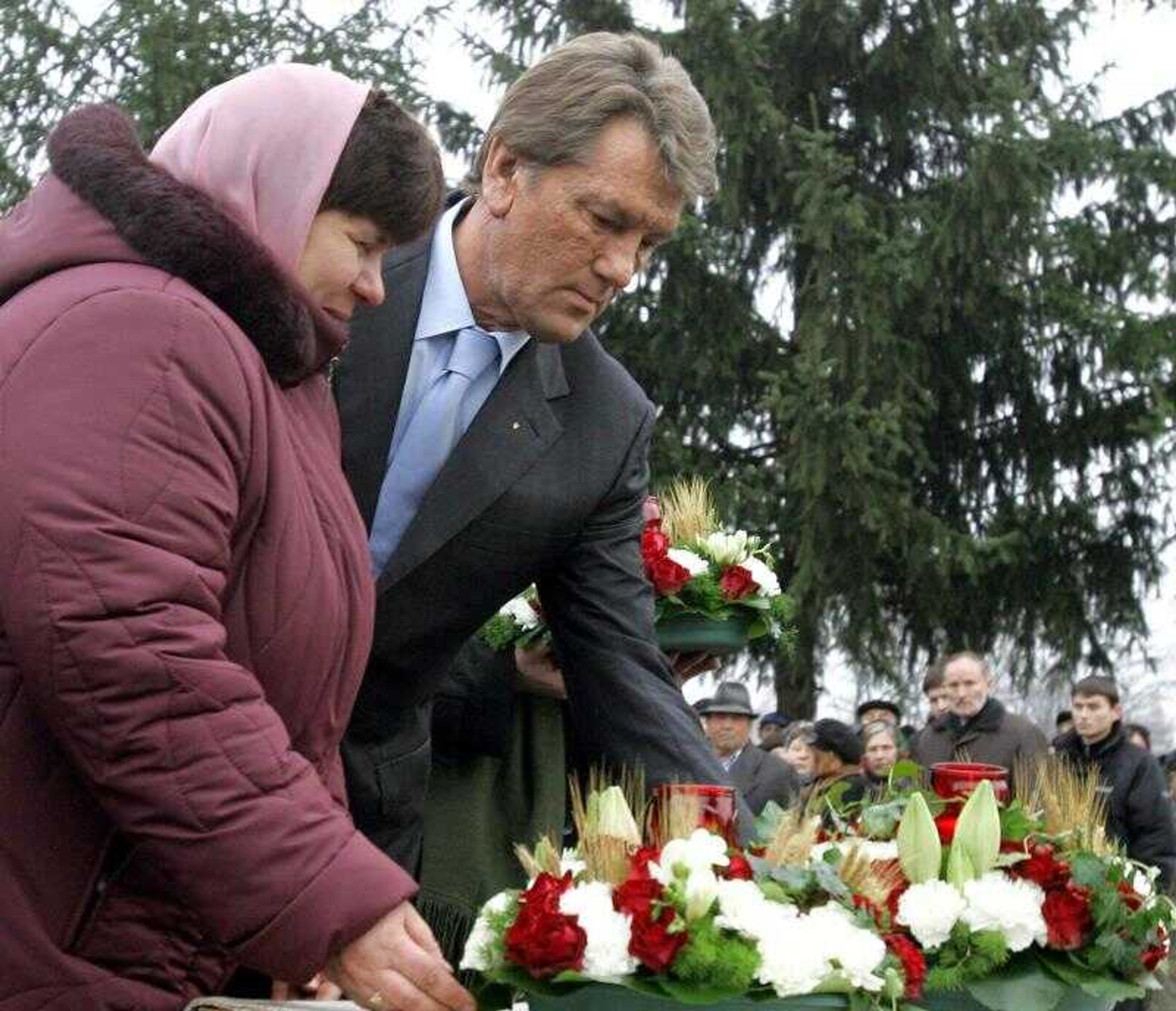 Ukraine President Viktor Yushchenko and a Ukrainian woman lay flowers Friday at the monument to victims of the Soviet-era famine during a ceremony in the village of Sehiyvka, in the Cherhinivsky region of Ukraine. (MYKOLA LAZARENKO ~ Presidential Press Service)