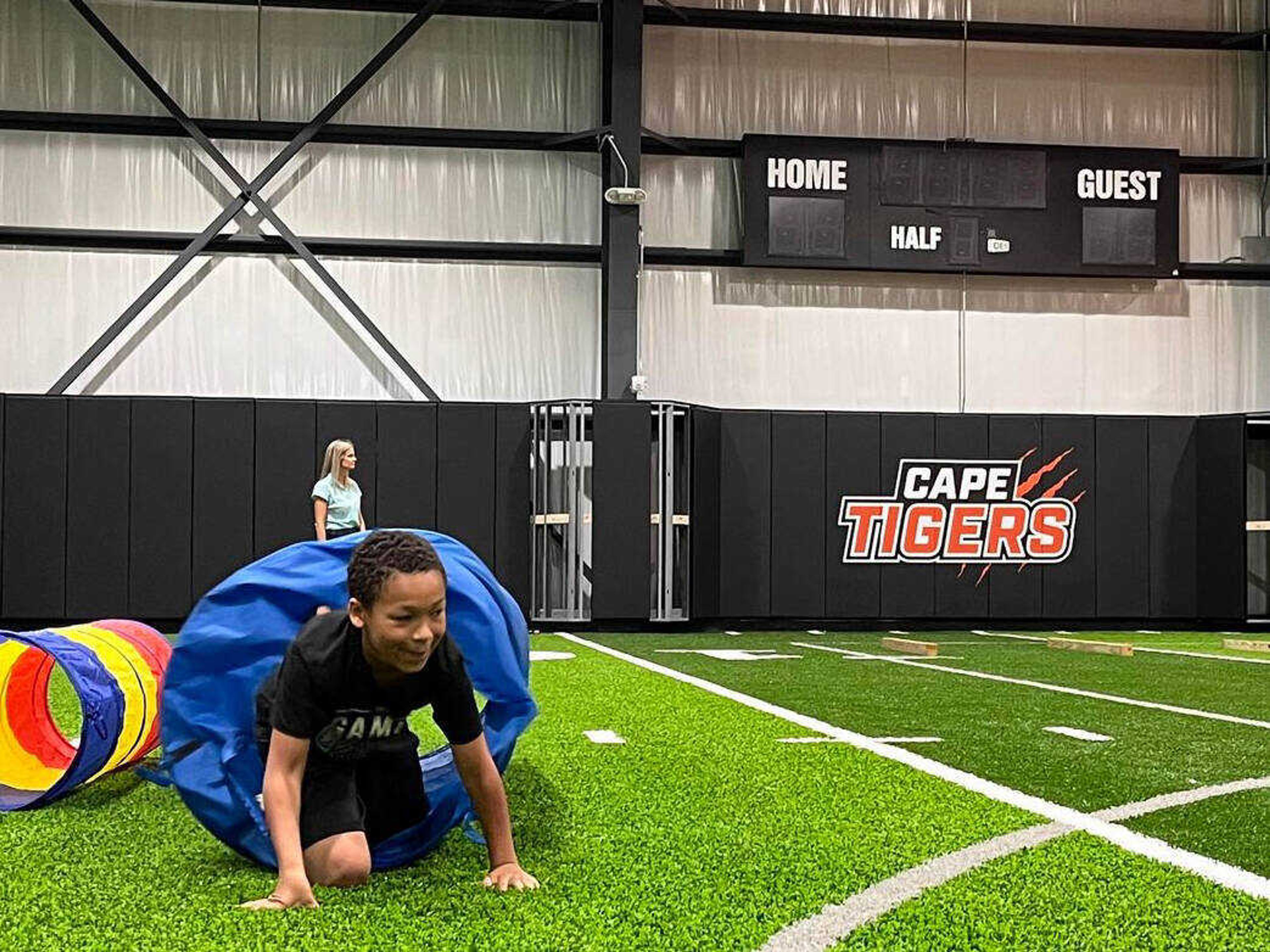 An elementary student crawls through the tunnel at the end of an obstacle course during the final day of summer school Friday, June 7, at Cape Central High School in Cape Girardeau.