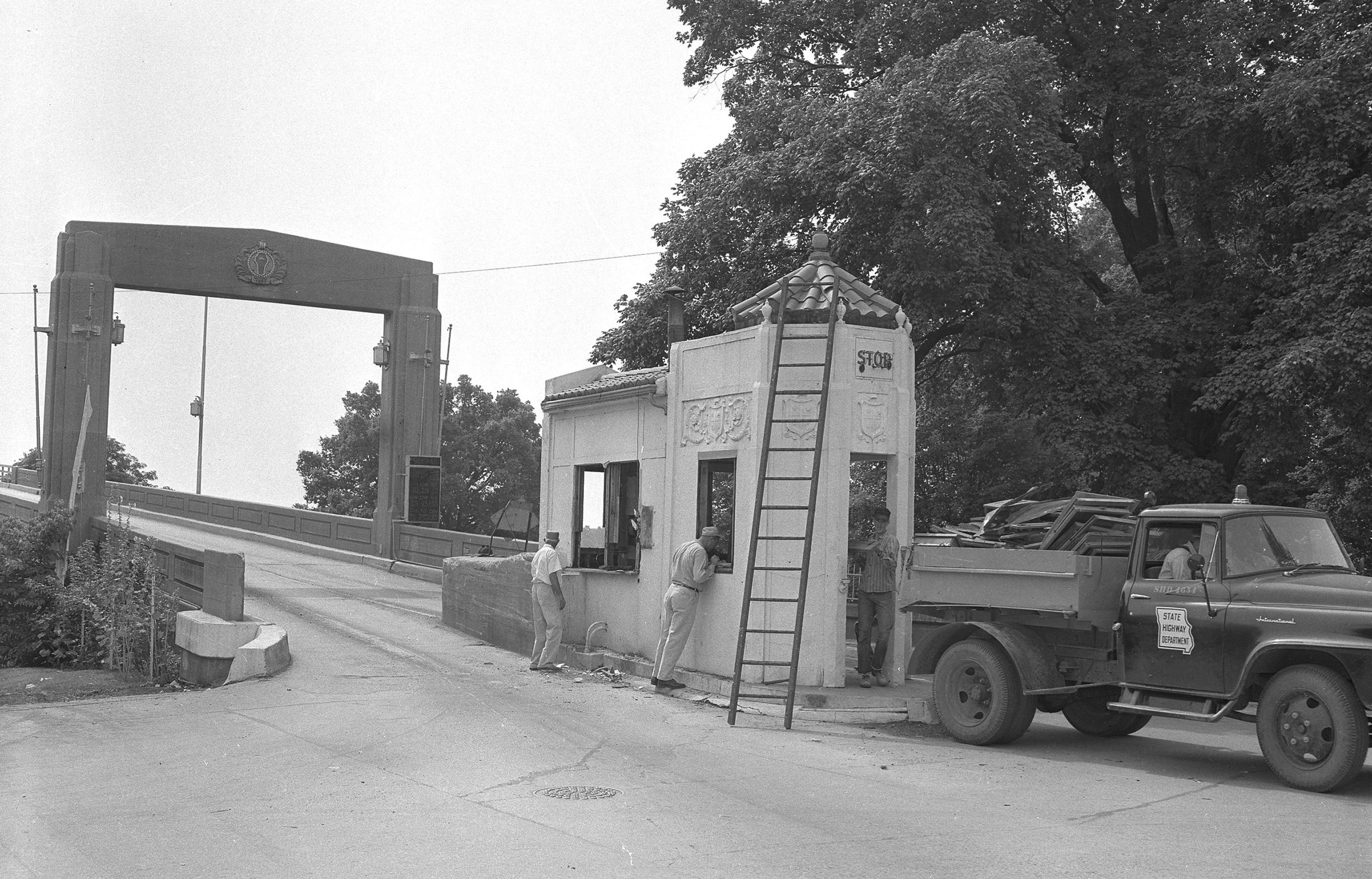 Following the freeing of the Mississippi River traffic bridge at Cape Girardeau, June 29, 1957, workers with the State Highway Department raze the reinforced concrete toll house on  the Cape Girardeau end of the span the following week.