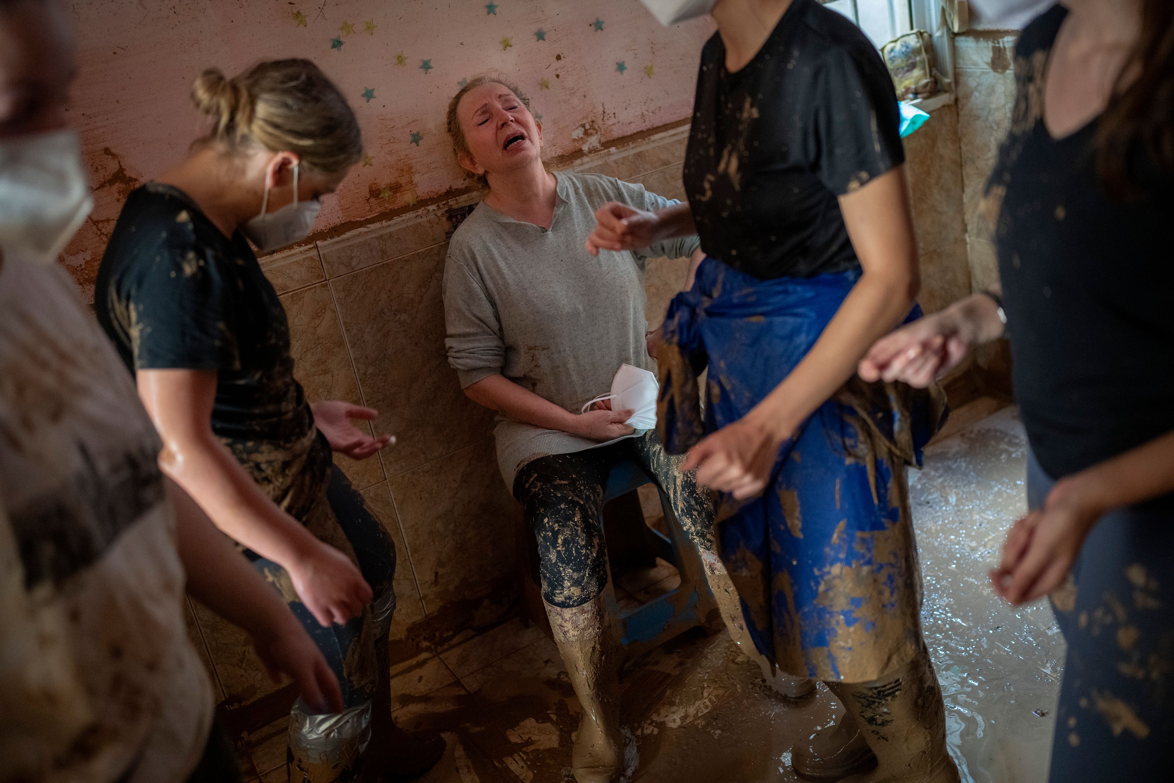 Dolores Merchan, 67, reacts in tears as she is assisted by volunteers clearing mud from her home, where she has lived all her life with her husband and three children, and which has been severely affected by the floods in Masanasa, Valencia, Spain, Thursday, Nov. 7, 2024. (AP Photo/Emilio Morenatti)