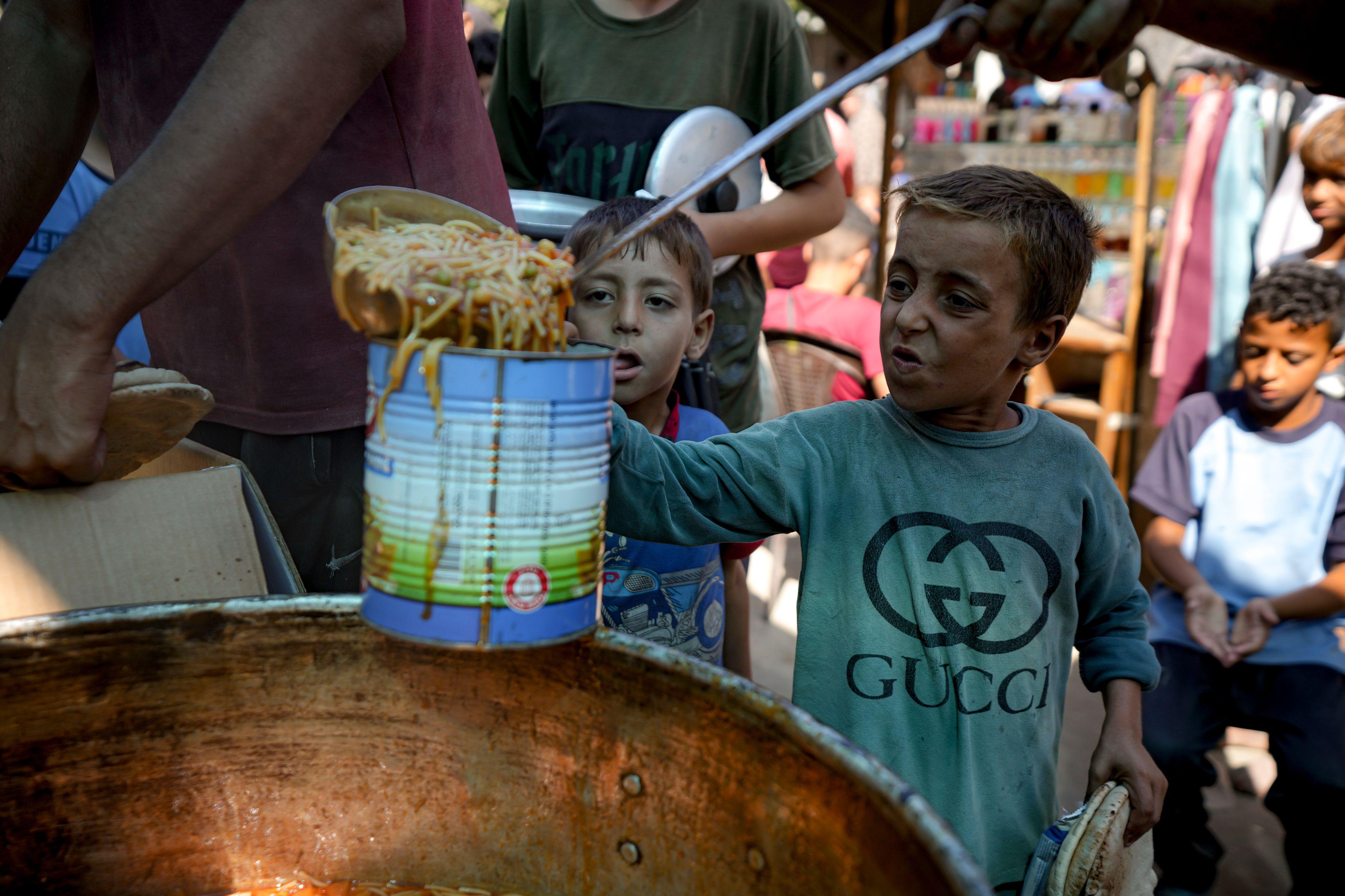 FILE - A displaced child lines up for food distribution in Deir al-Balah, Gaza Strip, on Oct. 17, 2024. (AP Photo/Abdel Kareem Hana, File)