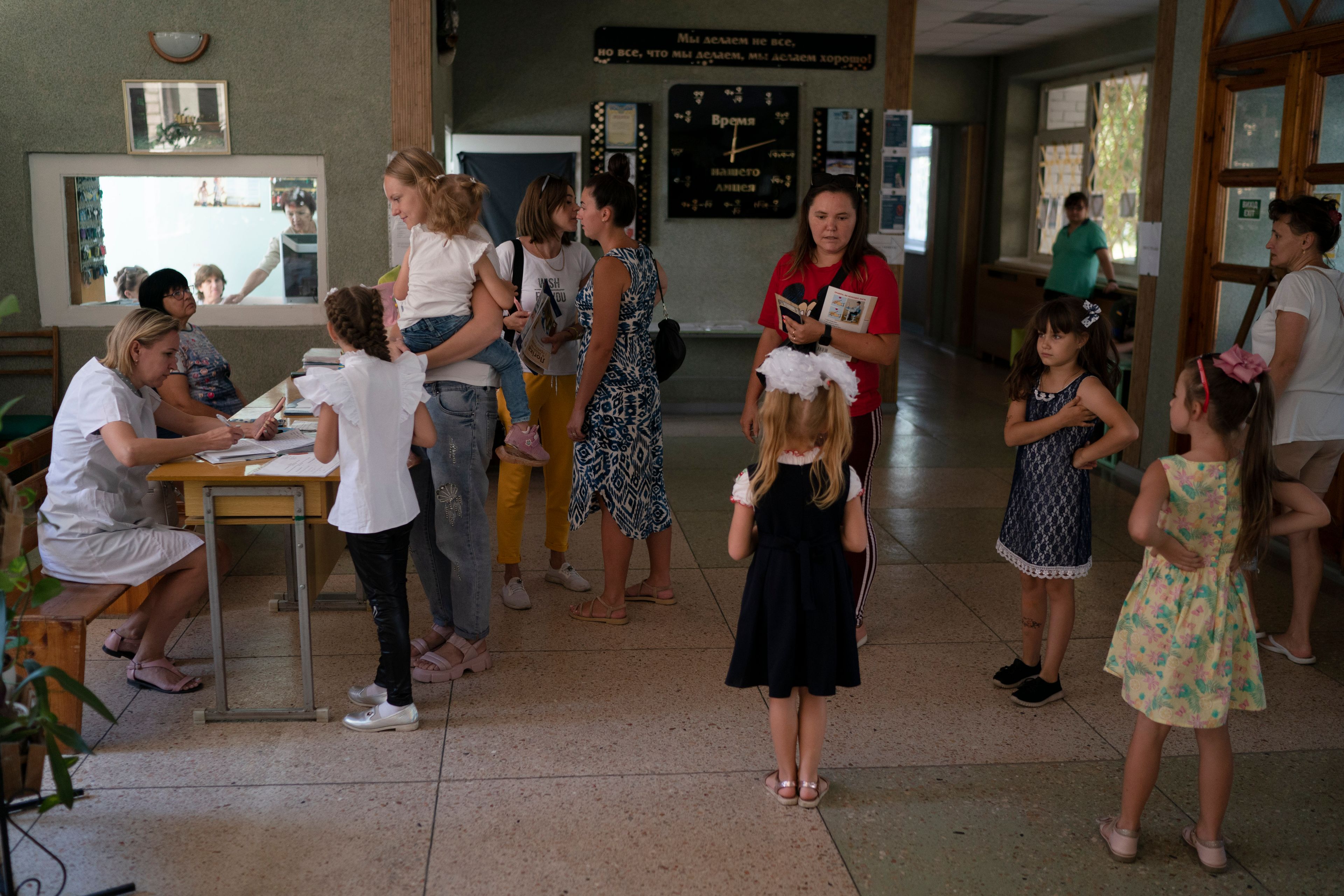 FILE - In this Sept. 2, 2022, file photo, people wait to receive iodine tablets being distributed at a school in case of a radiation leak in Zaporizhzhia. The city faces the twin threats of daily Russian bombs and fears of radiation from the Russian-controlled nuclear power plant nearby. (AP Photo/Leo Correa)