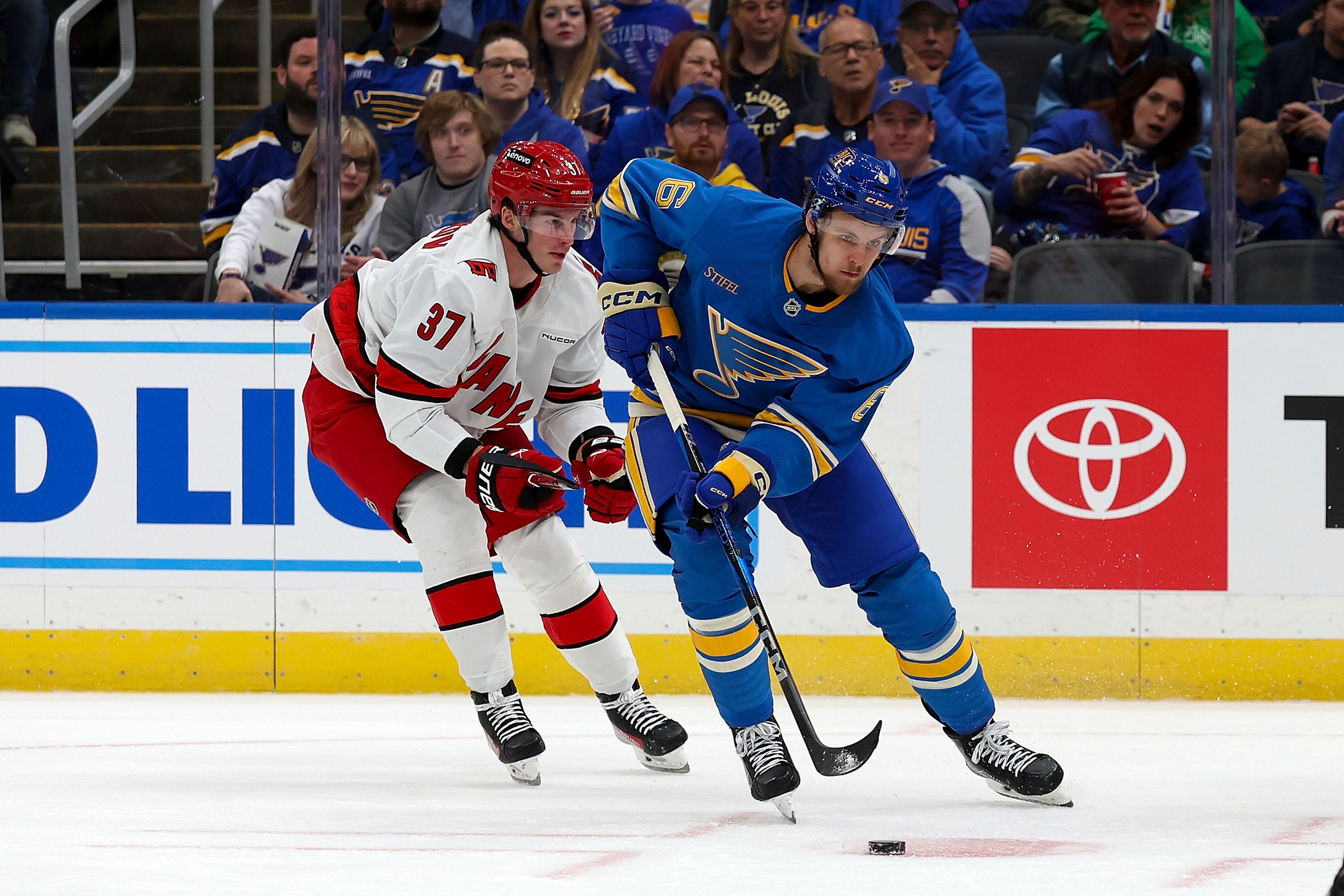 St. Louis Blues' Philip Broberg (6) controls the puck while under pressure from Carolina Hurricanes' Andrei Svechnikov (37) during the second period of an NHL hockey game Saturday, Oct. 19, 2024, in St. Louis. (AP Photo/Scott Kane)