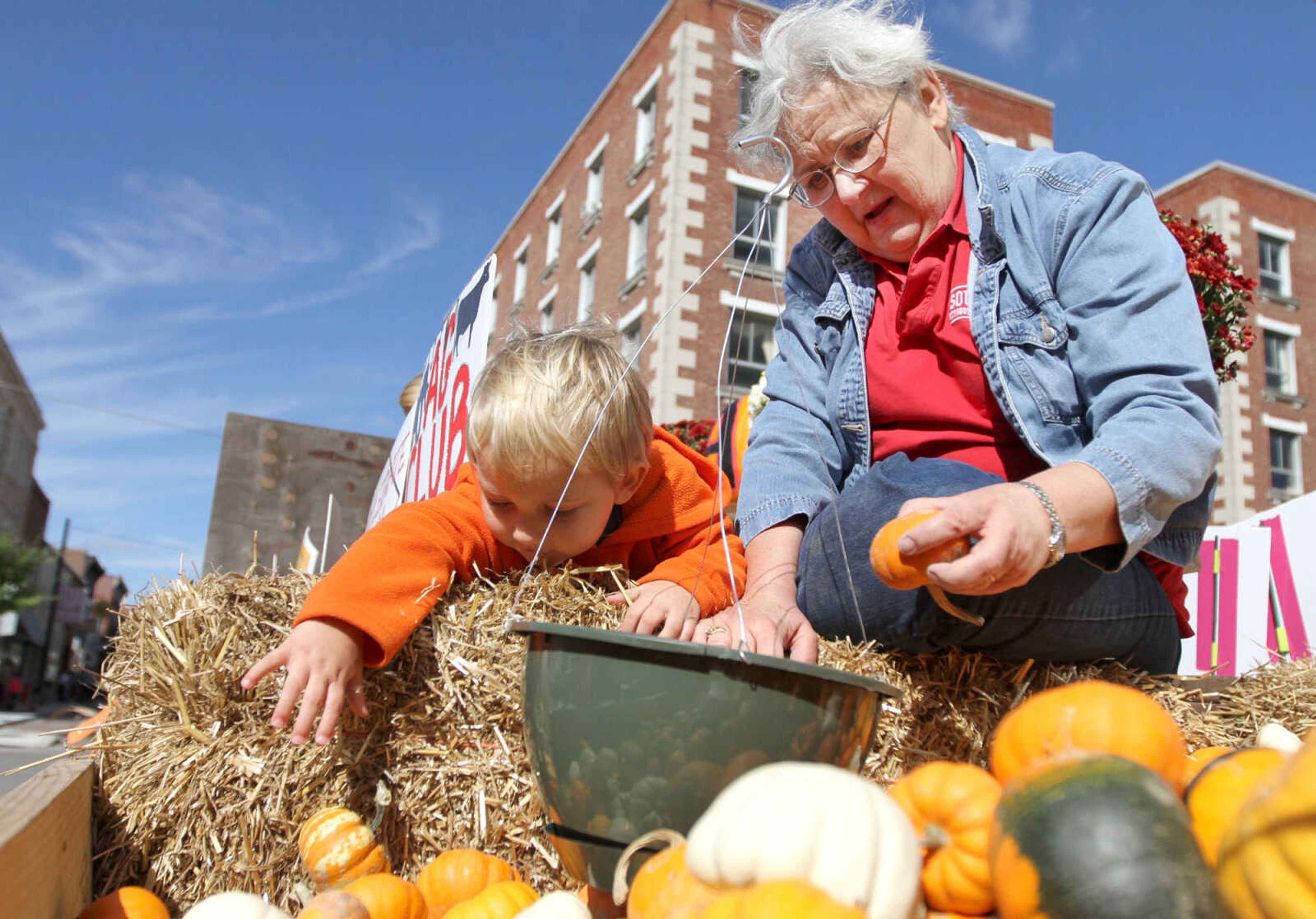 GLENN LANDBERG ~ glandberg@semissourian.com

Max Smith, 2, reaches for a pumpkin with help from his grandmother, Christine Aide on the agriculture department float during the homecoming parade Saturday morning, Oct. 4, 2014.
The agriculture department handed out pumpkins to parade-goers along the route.