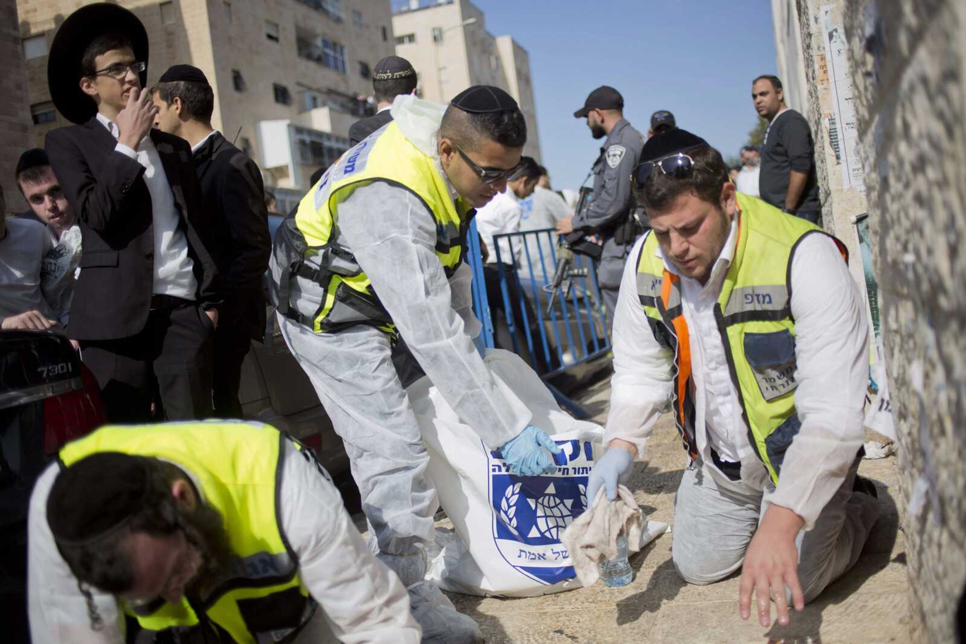 Israeli rescue workers clean blood from the scene of a shooting attack Tuesday in a synagogue in Jerusalem. (Associated Press)